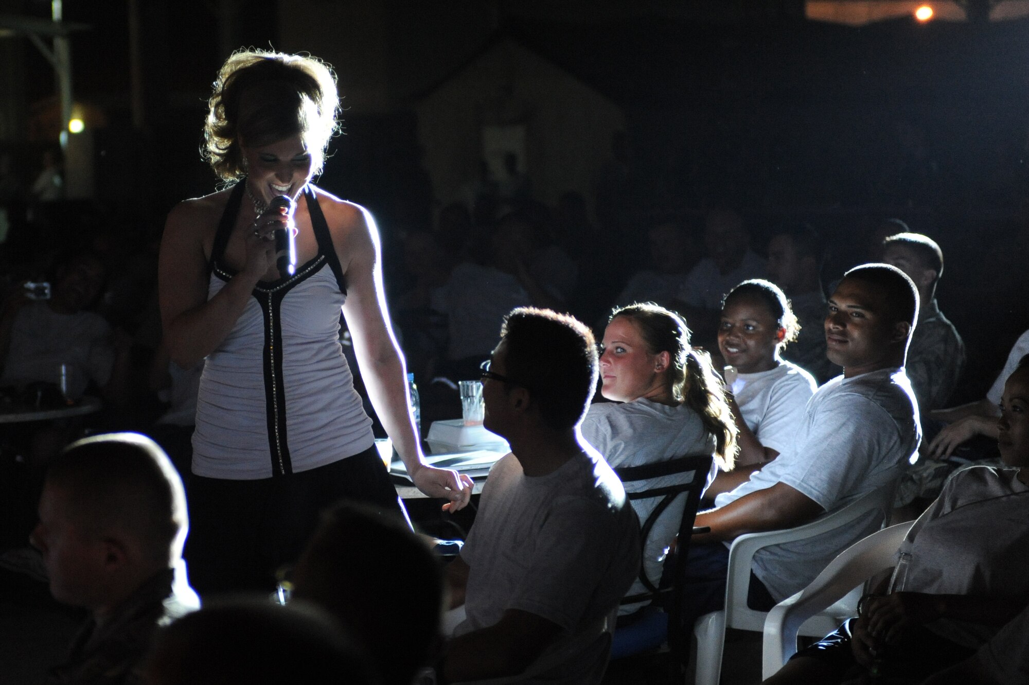 SOUTHWEST ASIA - Staff Sergeant Naomi Keen, Tops in Blue performer, walks through the audience filled with members of the 380th Air Expeditionary Wing July 27. Sergeant Keen is a Health Services Management Craftsman from the 59th Surgical Operations Squadron, Lackland Air Force base, Texas, and hails from Simpsonville, Texas. (U.S. Air Force photo Tech. Sgt. Charles Larkin Sr.)