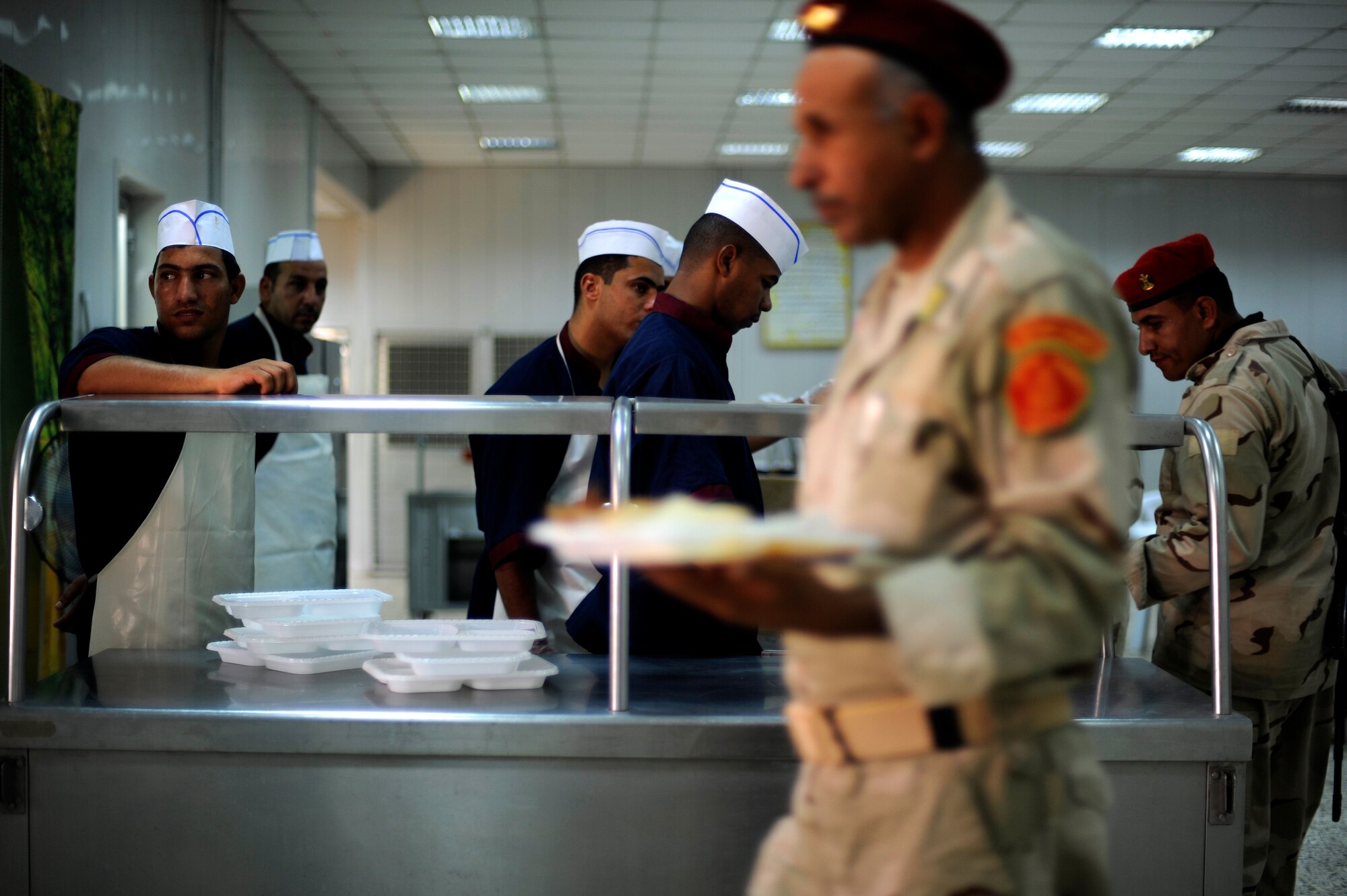 Iraqi Soldiers eat lunch at their dining facility at Camp Taji, Iraq, July 12, 2009.   This dining facility is run exclusively by the Iraqi Army with some assistance from an American Airman assigned to the Logistics Military Advisor Team.  (U.S. Air Force photo by Staff Sgt. Michael B. Keller) (Released) 
