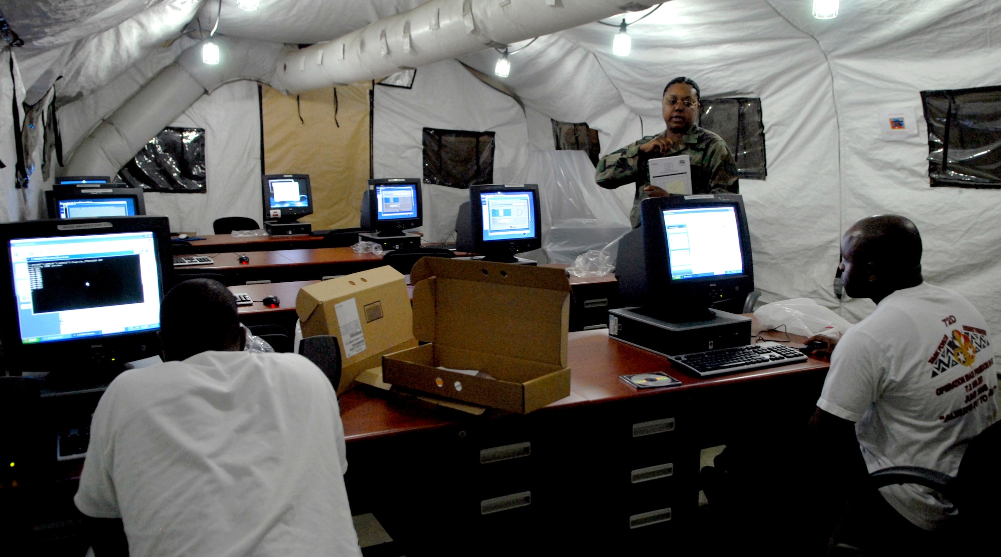 (Left) Senior Airman Jarvis Mitchell, (right) Technical Sgt. Rich Goines and Technical Sgt. Katrina Haskin place a standard desktop configuration on computers in Rush Park before Ulichi Freedom Guardian at Osan Air Base, Republic of Korea, July 30. UFG is a joint bilateral exercise expected to start in August, at Osan Air Base, Republic of Korea.  More than 550 military members will participate in the exercise. UFG is a regularly scheduled summer exercise involving forces from both the Republic of Korea and the U.S. (U.S. Air Force photo/Senior Airman Stephenie Wade)
