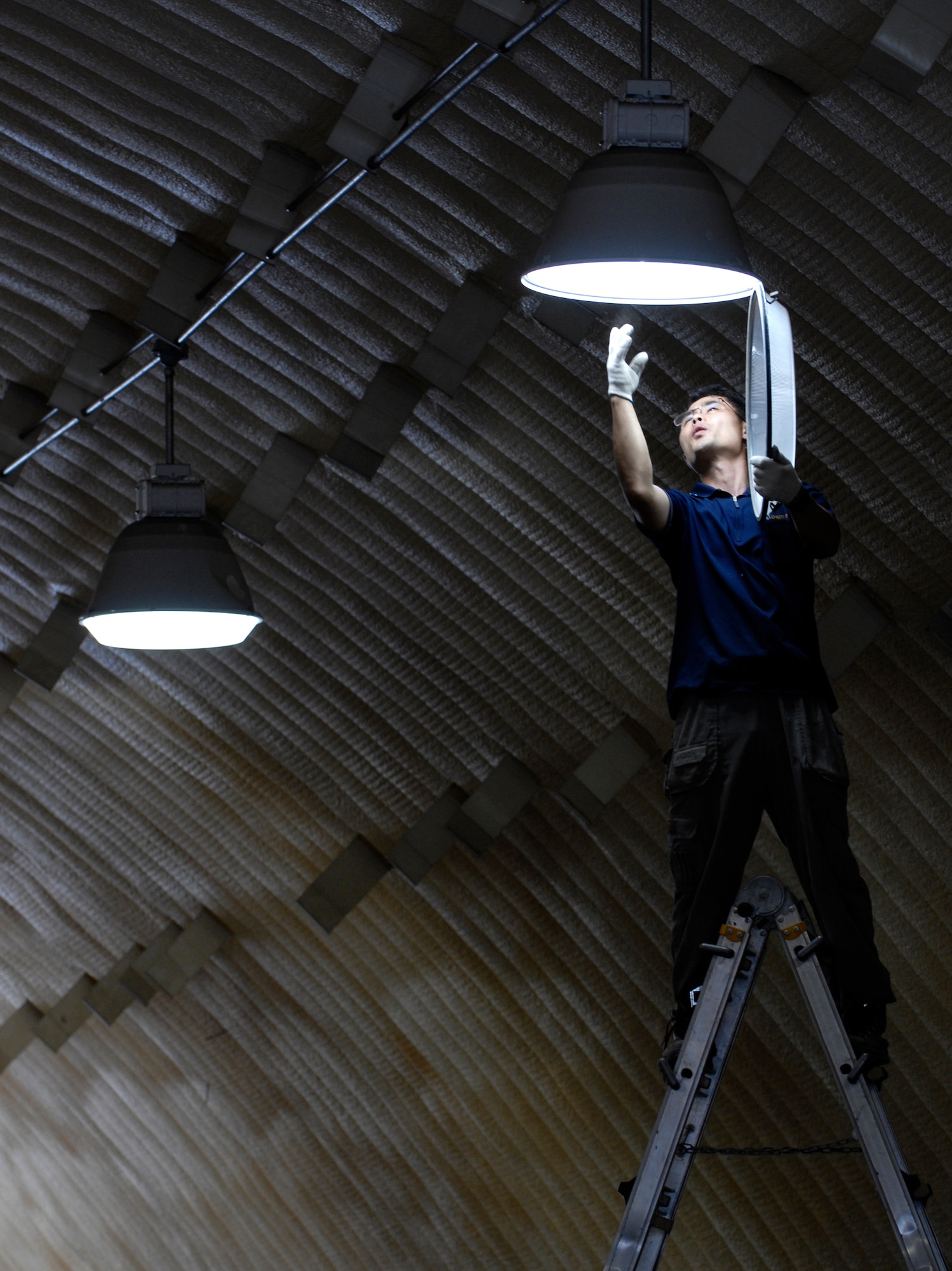 Contract Electrician Konho Yi replaces a metal halide bulb in one of the K-SPAN housing units at Rush Park (tent city) on  Osan Air Base, Republic of Korea July 28. The bulbs are being replaced in preparation for Ulchi Freedom Guardian, a joint bilateral exercise expected to start in August. More than 550 military members will participate in the exercise. UFG is a regularly scheduled summer exercise involving forces from both the Republic of Korea and the U.S. (U.S. Air Force photo/Senior Airman Stephenie Wade)

