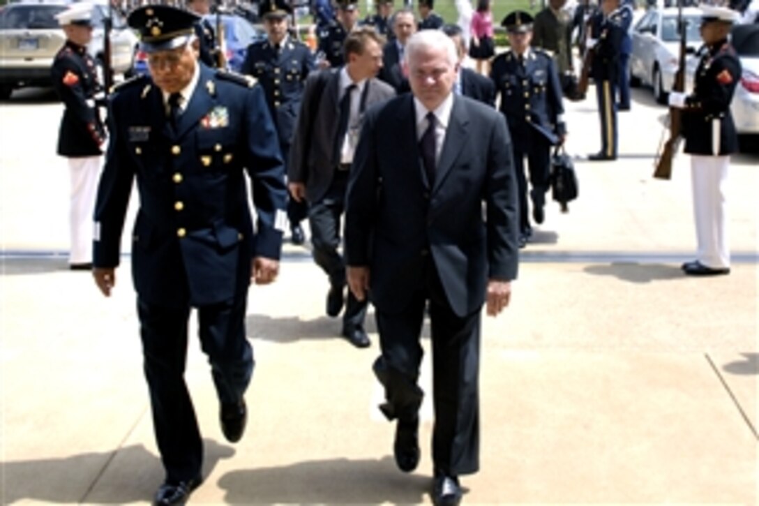 U.S. Defense Secretary Robert M. Gates, right, and Mexican Defense Secretary Gen. Guillermo Galvan walk through a cordon of honor gaurds into the Pentagon after a full honors arrival ceremony, July 30, 2009. 