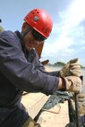 Lt. Col. Charles Long, executive officer, Chemical Biological Incident Response Force, II Marine Expeditionary Force, works to move a piece of concrete using cribbing and shoring techniques at the final practical application for students, during the CBIRF Basic Operations Course, at Navy Annex Stump Neck, Md., July 30, 2009.  Marines and sailors who attended the CBOC learned various techniques for search and extraction during potential chemical, biological, radiological, nuclear and high-yield explosive incidents.