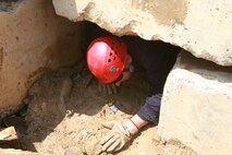 Lt. Col. Charles Long, executive officer, Chemical Biological Incident Response Force, II Marine Expeditionary Force, exits a collapsed structure after rescuing a simulated casualty, as part of the CBIRF Basic Operations Course final practical application at Navy Annex Stump Neck, Md., July 30, 2009.  Marines and sailors who attended the CBOC learned various techniques for search and extraction during potential chemical, biological, radiological, nuclear and high-yield explosive incidents.
