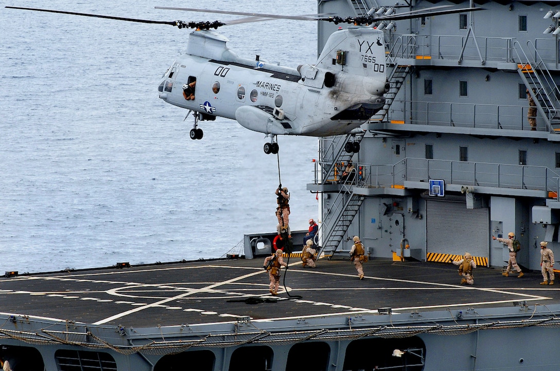 Marines assigned to the Ground Combat Element of the 11th Marine Expeditionary Unit, embarked amphibious dock landing ship USS Rushmore (LSD 47), fast rope out of a CH-46E Sea Knight on to the deck of the Military Sealift Command fleet replenishment oiler USNS Yukon (T-AO 202) during a visit, board, search and seizure exercise. Rushmore is part of the Bonhomme Richard Amphibious Ready Group and is underway conducting a Composite Training Unit Exercise (COMPTUEX) in preparation for a scheduled deployment to the western Pacific Ocean later this year.