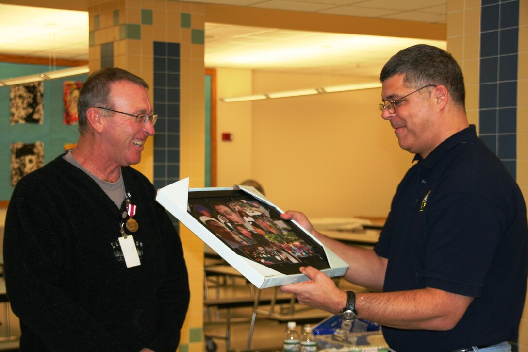 Winchester, MA:  Prior to his final concert, SMSgt Bill Drury (right), conductor, presents retiring SSgt Jack Chagnon (left) with a photo collage highlighting some of Jack's most memorable "off-stage" moments of his career.  SSgt Chagnon retired in December, 2008, with a combined full-time and part-time total of over 35 years of service in the Air National Guard. 