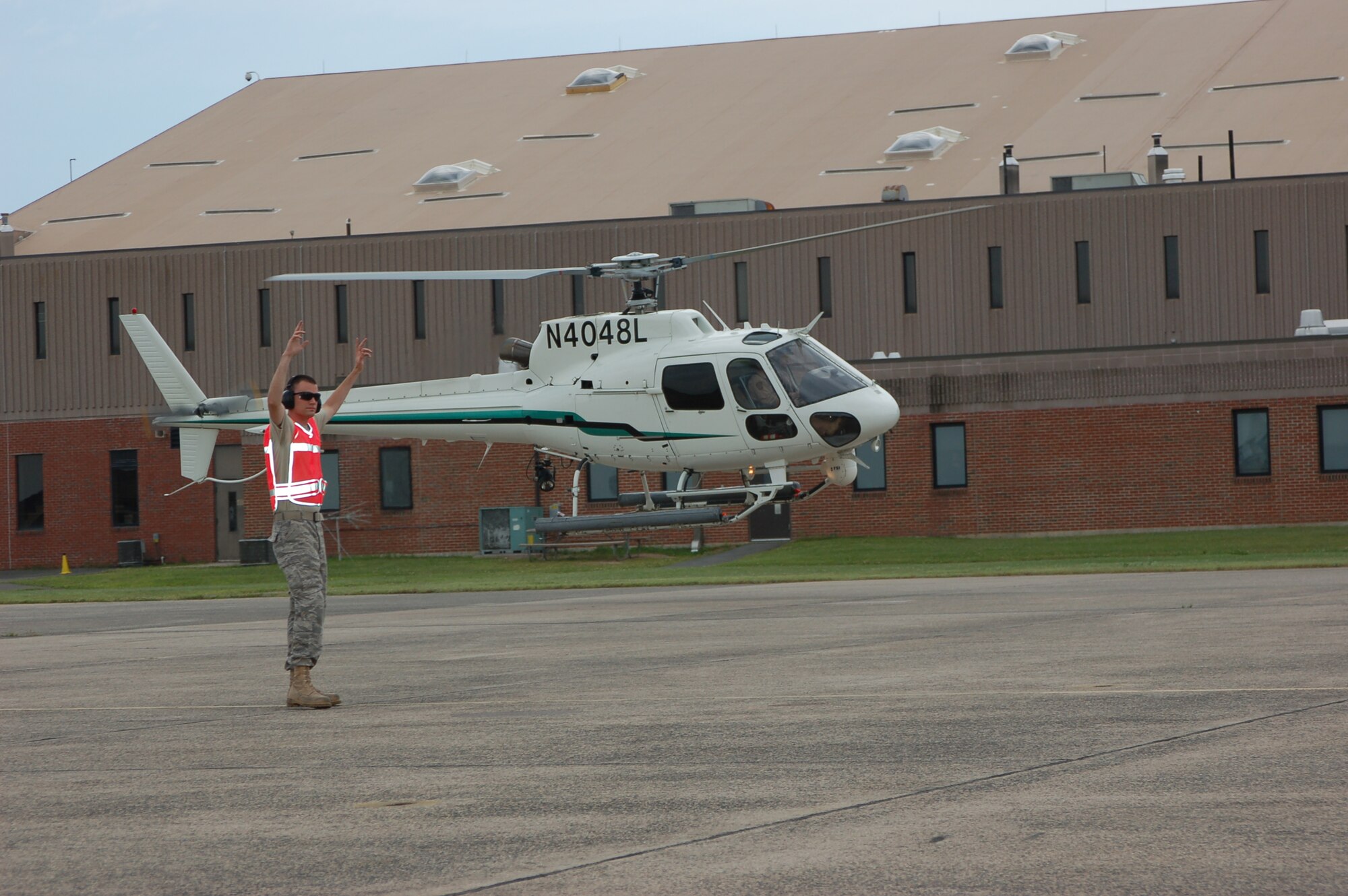 Tech. Sgt. Joshua Marks, crew chief, 103rd Aircraft Maintenance Squadron, gives direction to a Department of Homeland Security AS350B helicopter as it lands at Bradley ANG Base, East Granby, Conn. for Space and Aviation Day July 18, 2009. The helicopter was flown by Maj. Brian Hebert, C-21 pilot, 103rd Airlift Squadron.  It is estimated that approximately 5,000 people came through the gates of the base to check out the static displays.  (U.S. Air Force photos by Tech. Sgt. Joshua Mead)