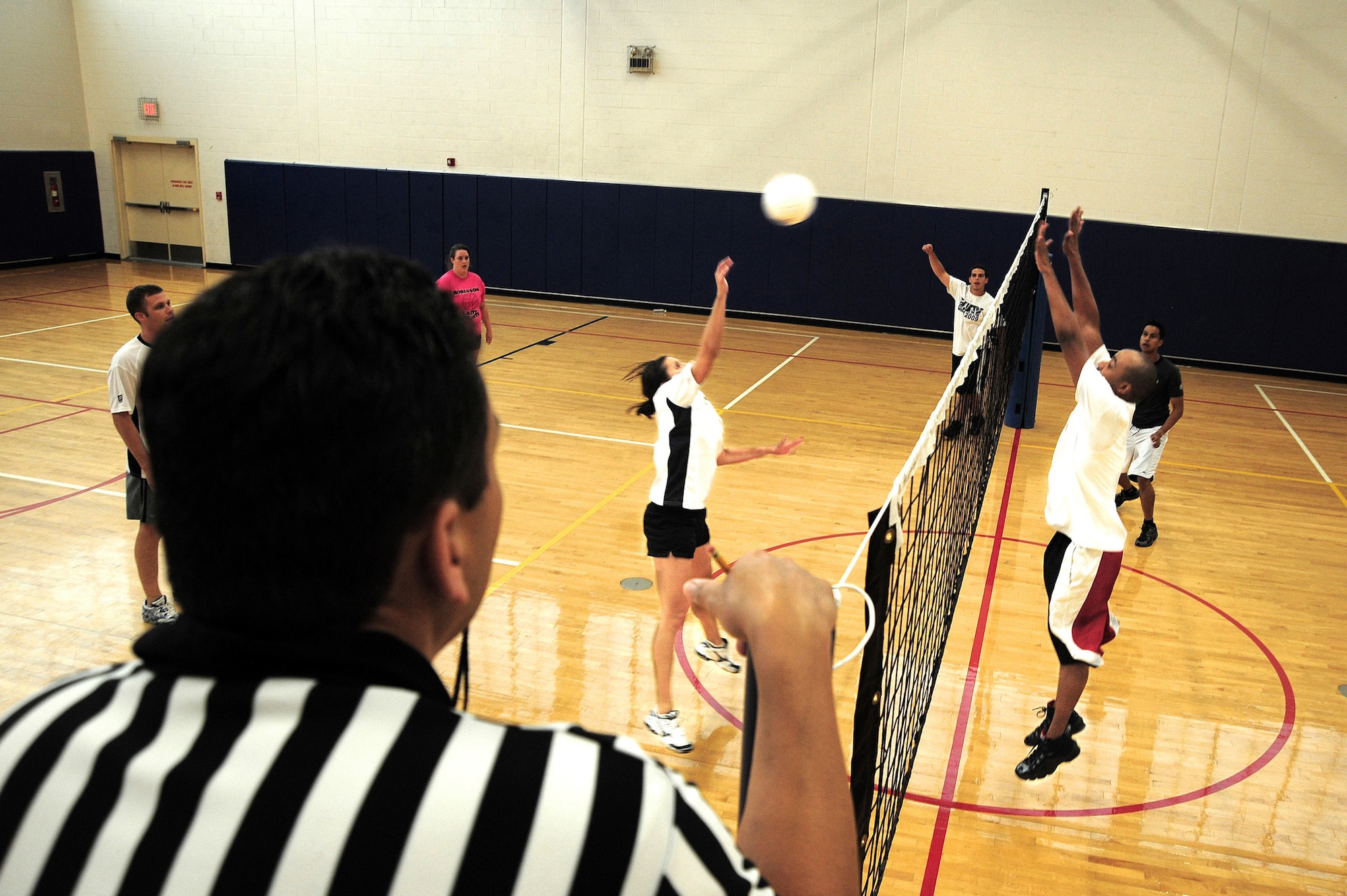 Demarcus Hunt, team FSS, goes up for a block against Liz Wehr, team Med Group B, during an intramural volleyball game at the Fitness Center here, July 22. FSS defeated Med Group B 2-1. After the match, FSS improves their record 2-3. (U.S. Air Force Photo by Staff Sgt. Joe Swafford)