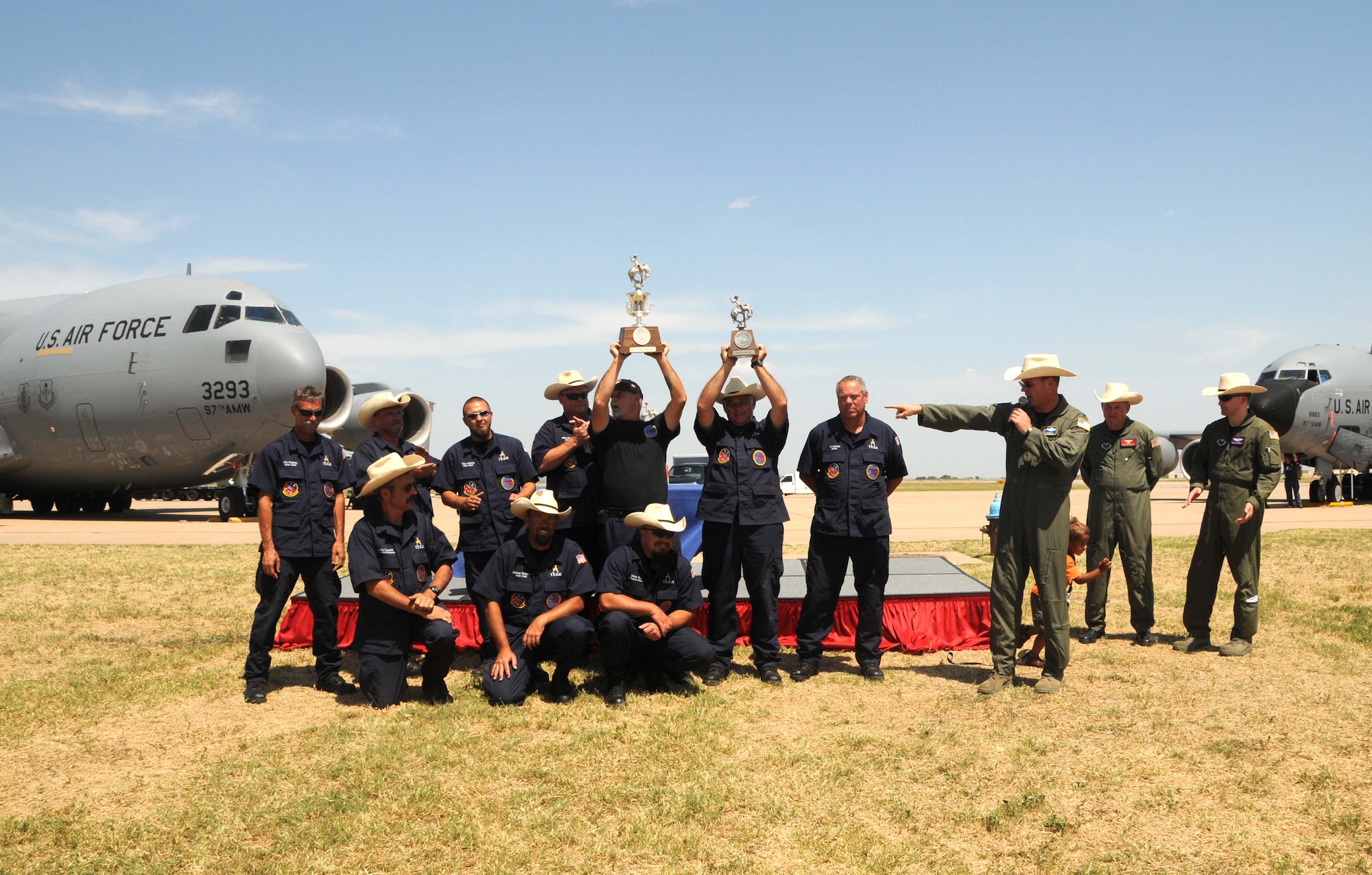 ALTUS AIR FORCE BASE, Okla. -- The KC-135 Maintenance team hoists their two trophies as Col. Jon "Ty" Thomas, 97th Air Mobility Wing commander, emcees the return home celebration July 25. The KC-135 Maintenance team won Best KC-135 Pre-flight Team and Best KC-135 Maintenance Team during the 2009 Air Mobility RODEO at McChord AFB, Wash., during the week prior. (U.S. Air Force photo/Senior Airman Cherice Bryant)