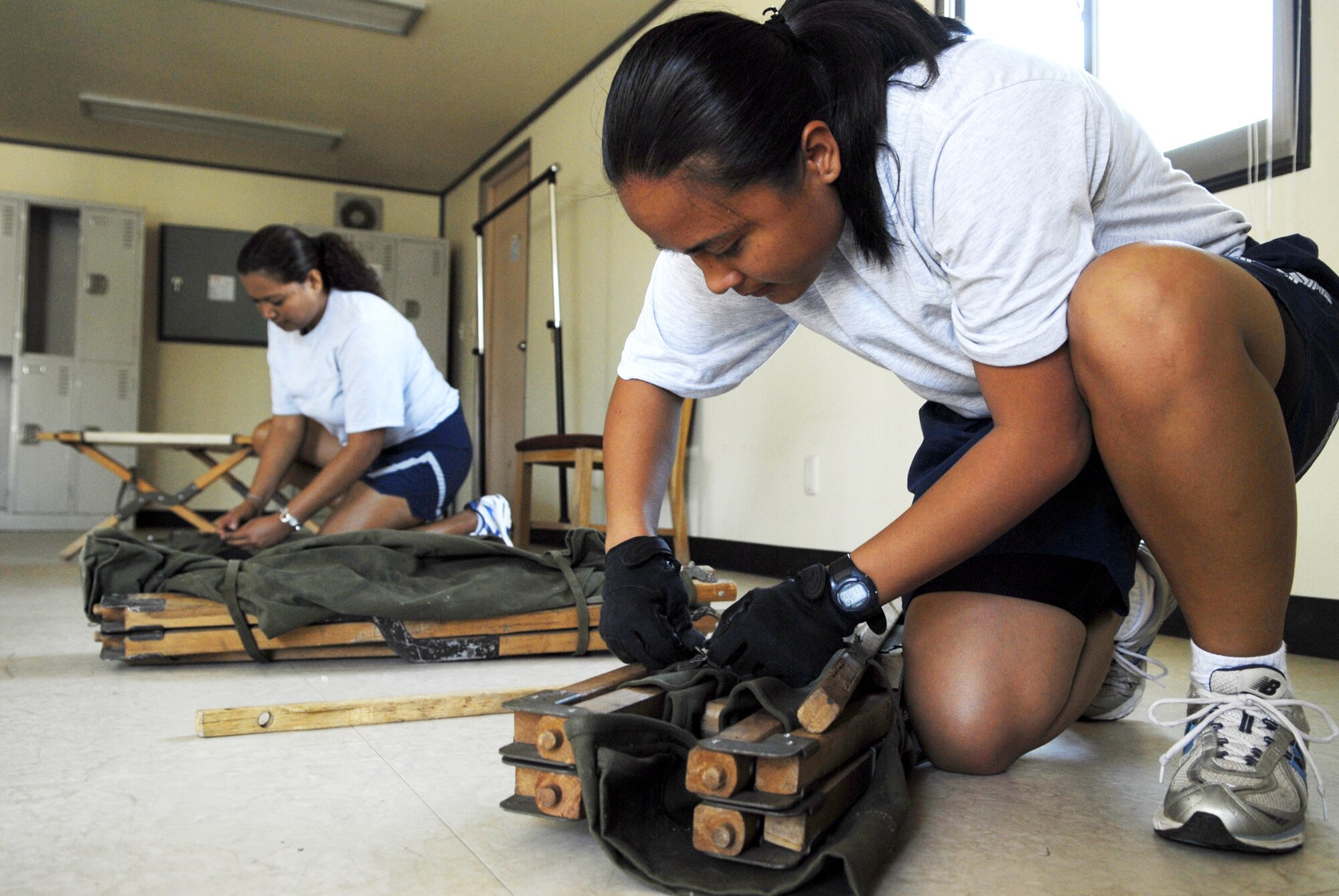 Staff Sgt. Venessa Salas, (right), and Staff Sgt. Cindy Fejaran unpack and assemble cots July 29 in preparation for Ulchi Freedom Guardian, a joint bilateral exercise set to start in August at Osan Air Base, South Korea. More than 550 military members will participate in the exercise. Sergeants Sala and Fejaran are deployed here from the 254th Force Support Squadron from Andersen Air Base, Guam. (U.S. Air Force photo/Senior Airman Stephenie Wade)