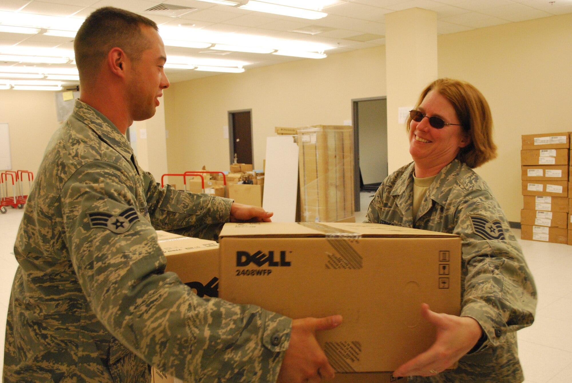 Senior Airman Sean Vaclavik and Tech. Sgt. Dara Febres, communications computer systems craftsmen, 103rd Air and Space Operations Group, receive a shipment of mission critical computer equipment for the new Combined Air Operations Center facility in Southwest Asia May 29, 2009.  The Airmen deployed as part of an eight-member team focused on enhancing command and control capabilities for Air Force operations in theater.  (U.S. Air Force photo by Lt. Col. Reid Christopherson)