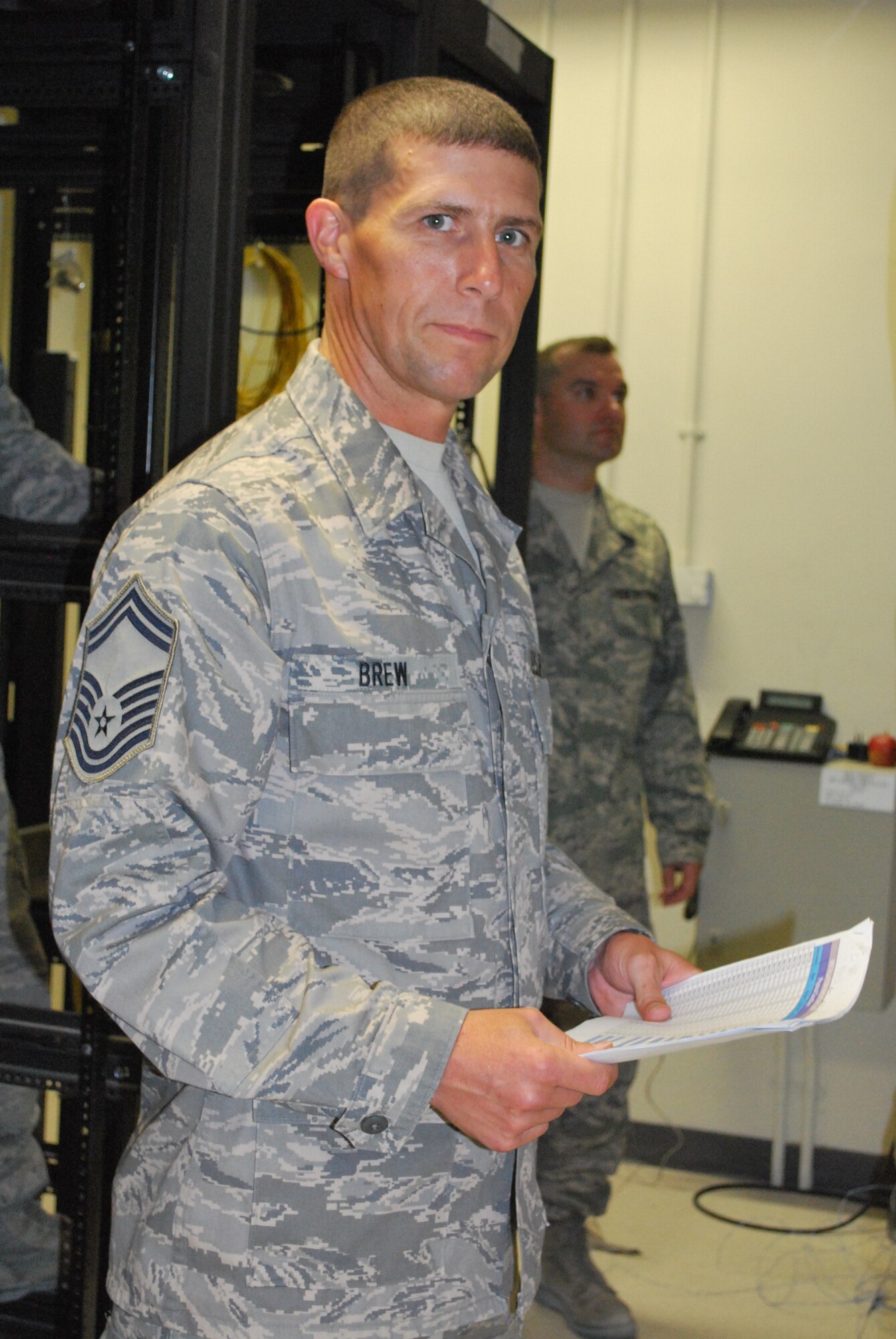 Senior Master Sgt. Scott Brew, superintendent, 103rd Air Communications Squadron, provides oversight and leadership to the team charged with installing a new DSN phone system at the new Combined Air Operations Center facility in Southwest Asia May 29, 2009.  Senior Master Sgt. Brew led a deployed eight-member team focused on enhancing command and control capabilities for Air Force operations in theater.  (U.S. Air Force photo by Lt. Col. Reid Christopherson)
