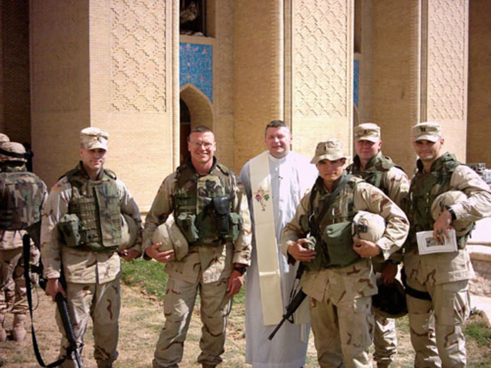 This photo, published in a 2004 Stars and Stripes article, features Chaplain Ken Beale (center), then rank of captain, with a cutline that said he goes into harm's way to deliver Mass while deployed to Iraq. Recently the Eglin AFB Catholic chaplain started recording songs he wrote and performed throughout his military career that reflect on his experiences. Chaplain (Maj.) Beale expects to sign a contract soon with a Tennessee recording company and have an album out by December. (U.S. Air Force photo)
