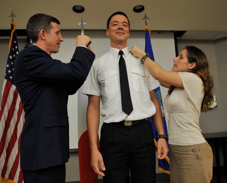 MOODY AIR FORCE BASE, Ga. -- Lt. Col. Thomas Kunkel, 41st Rescue Squadron commander, along with Melanie Vernet, wife of Capt. Guillaume Vernet, 41st RQS pilot, pin on the rank of major during a promotion ceremony here July 31. Captain Vernet is a French pilot assigned to the 41st RQS who is stationed at Moody as part of a three-year officer exchange program. (U.S. Air Force photo by Senior Airman Schelli Jones) 