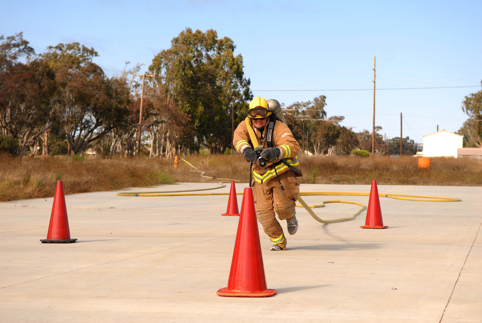 VANDENBERG AIR FORCE BASE, Calif.-- Matthew Stevens, a 30th Civil Engineer Squadron firefighter, runs with a fire hose draped over his shoulder to a finishing point during training July 29 here in preparation for the Firefighter Combat Challenge in October. (U.S. Air Force photo/Senior Airman Bryan Boyette)
 
