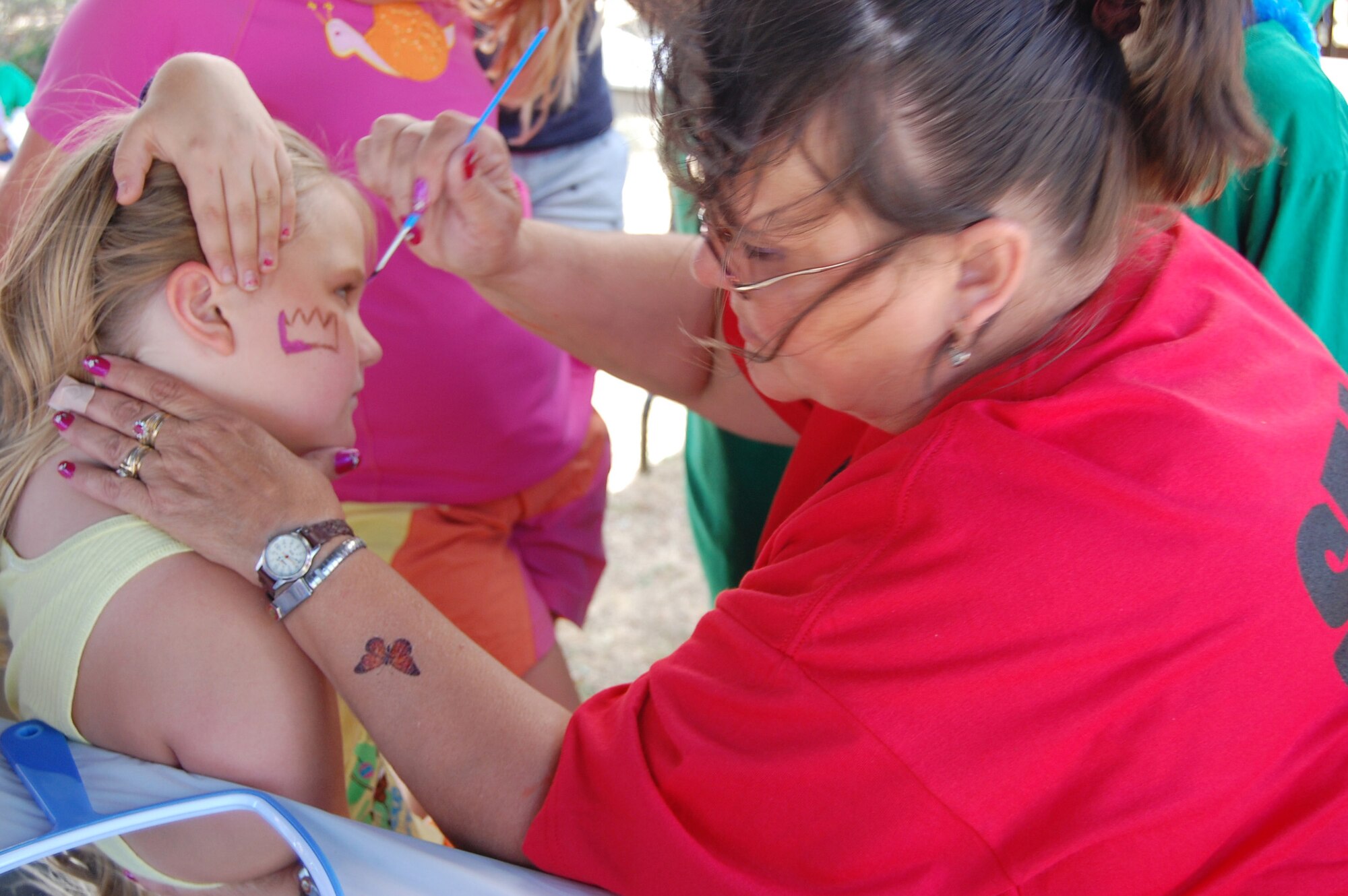 Lorraine Hersey, Child Development Center employee, paints the face of Little Warrior Becca, 9, at the annual base picnic July 24 at Sun Plaza Park. This was one of several activities offered strictly for Malmstrom's Little Warriors. (U.S. Air Force photo/Valerie Mullett)