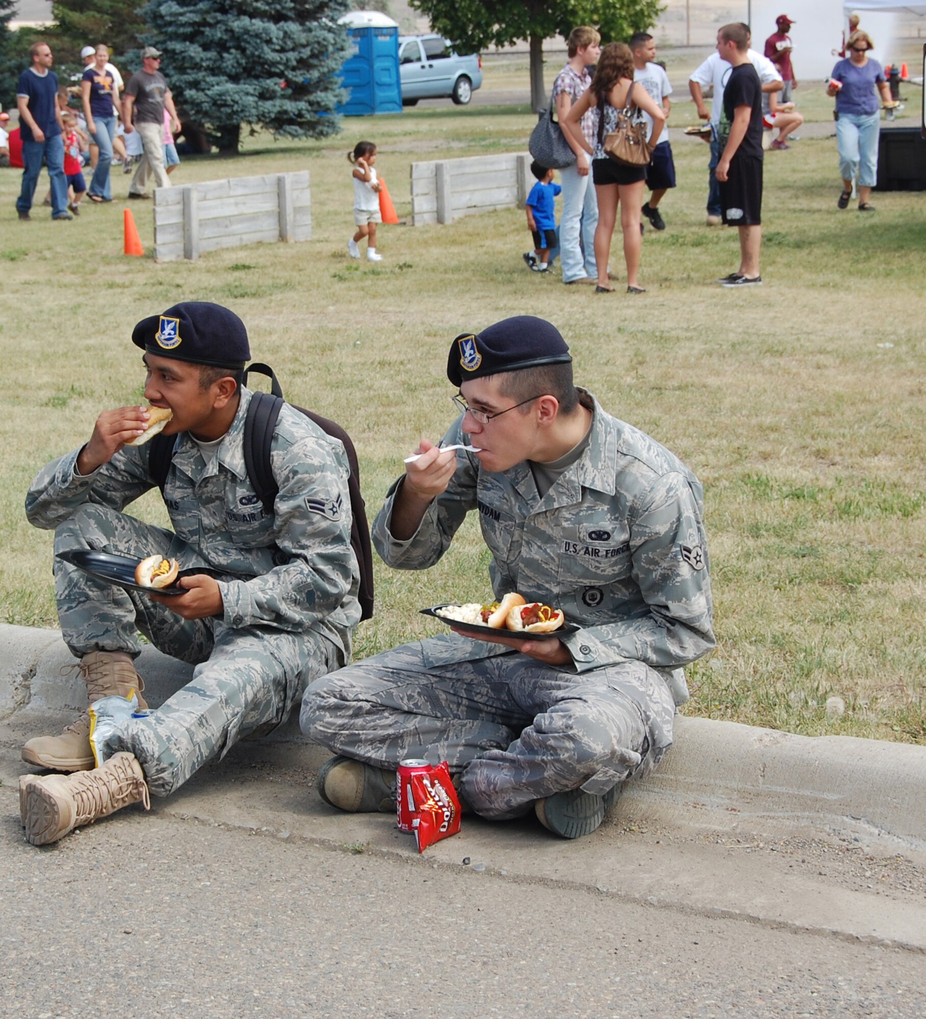 Airmen 1st Class Melecio Rosas (left) and Brendan Nydam, both 741st Missile Security Forces Squadron members, grab a bite to eat at the annual base picnic July 24.More than 3,000 people turned out for the festivities at Sun Plaza Park. (U.S. Air Force photo/Valerie Mullett)