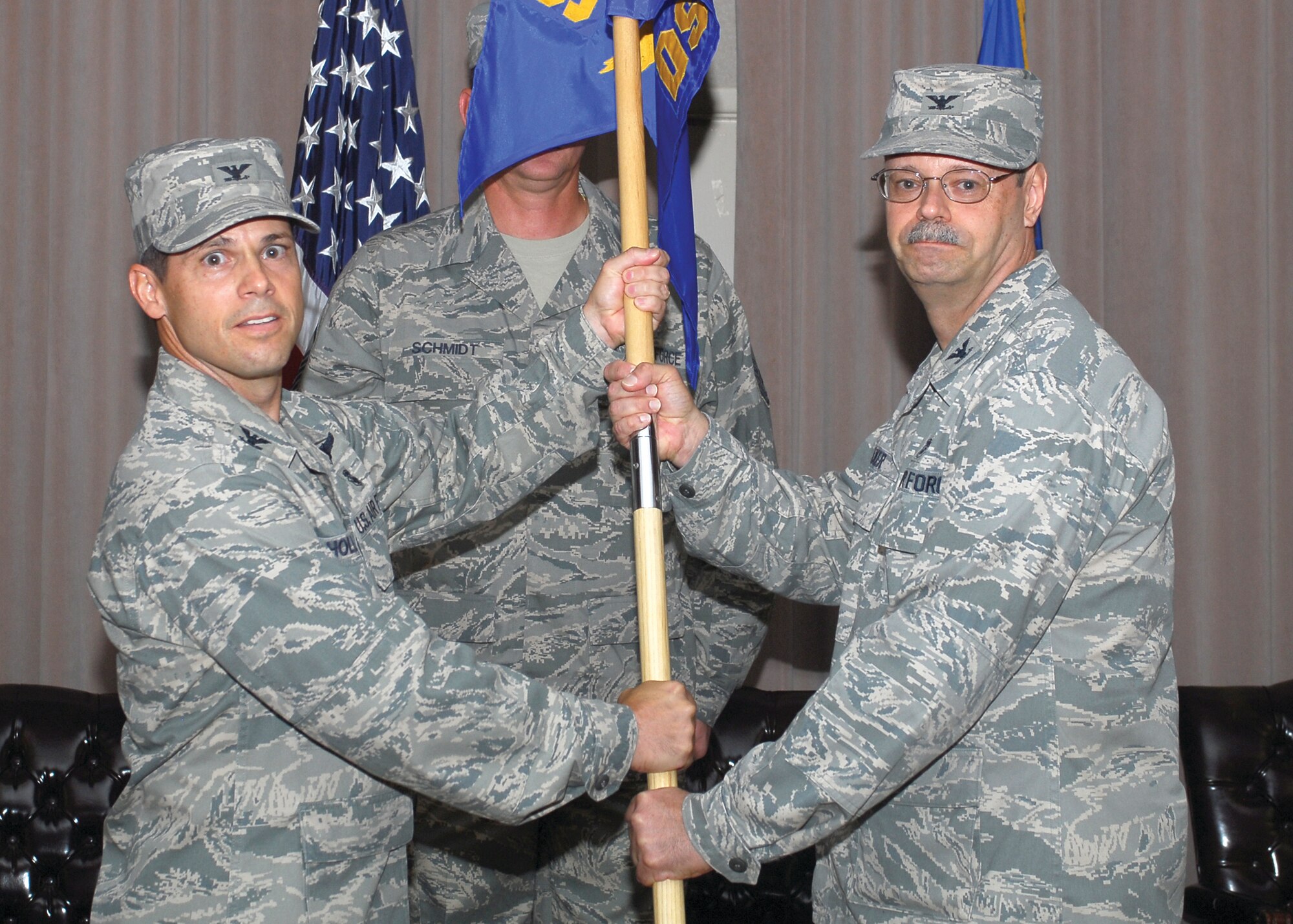 Col. Mark Holland, 56th Medical Group commander, hands the 56th Dental Squadron guidon to Col. Jeffery Baker, the new commander, during the change-of-command ceremony July 27. (U.S. Air Force photo by Senior Airman Tracie Forte)