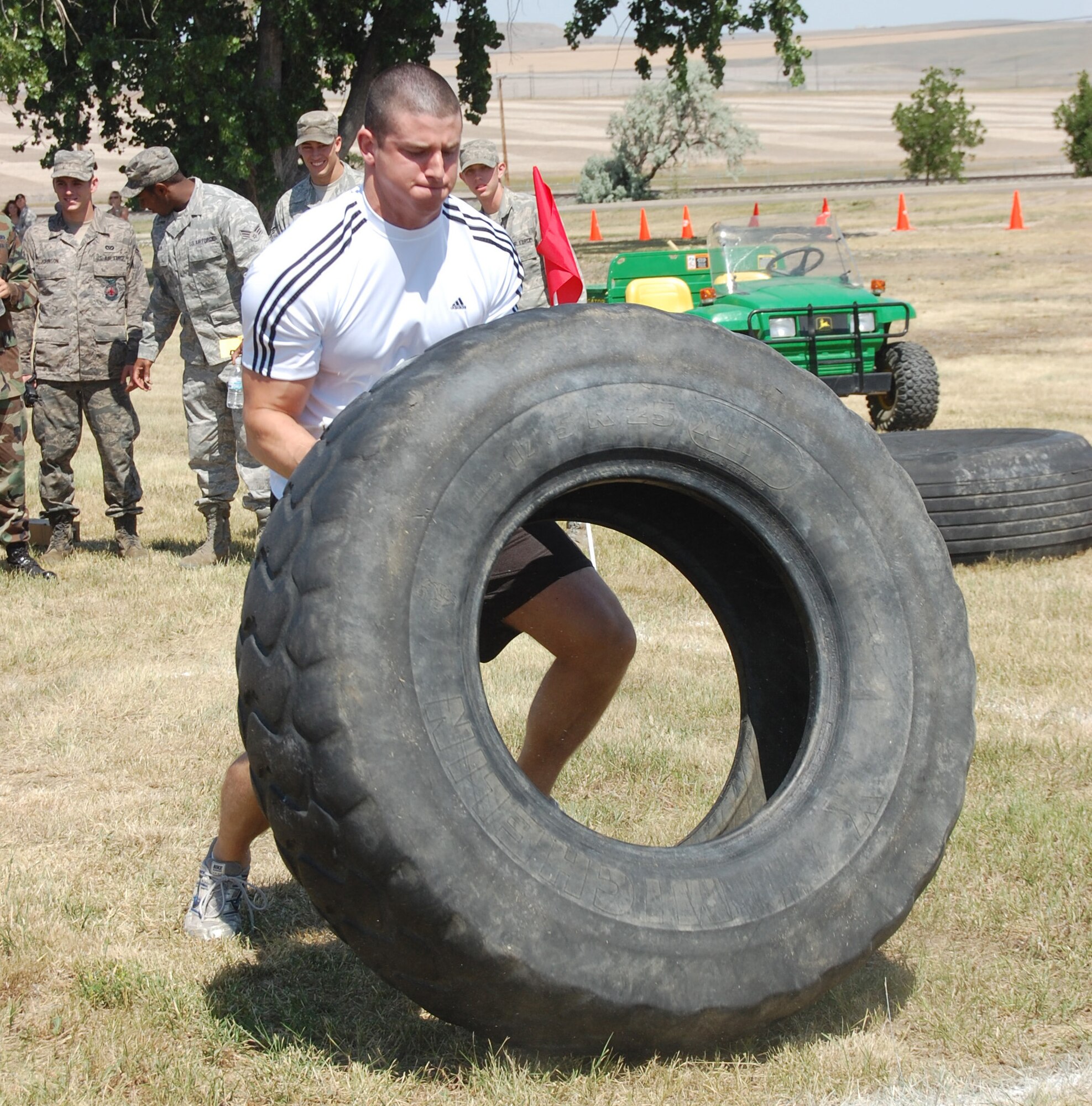 2nd Lt. Trevor Trujillo, 490th Missile Squadron, puts his all into the tire flip competition during the Grizzly Bend Challenge. This was the first of four events that made up the challenge, which was one of the highlights of the annual base picnic July 24. (U.S. Air Force photo/Valerie Mullett)