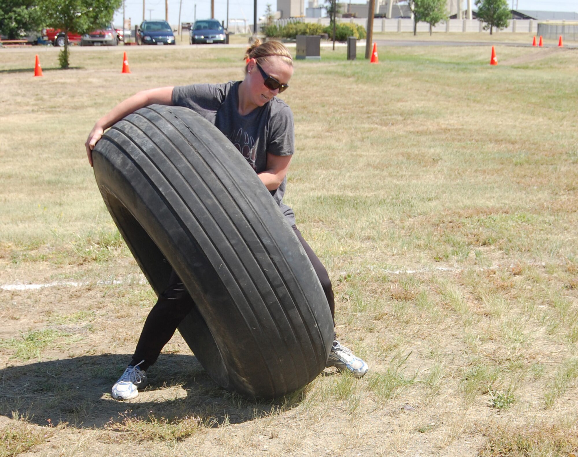 1st Lt. Taren Clement uses a different strategy to complete the tire flip portion of Grizzly Bend Challenge during the annual base picnic July 24 at Sun Plaza Park. She was the overall winner in the feamale heavyweight division. (U.S. Air Force photo/Valerie Mullett)