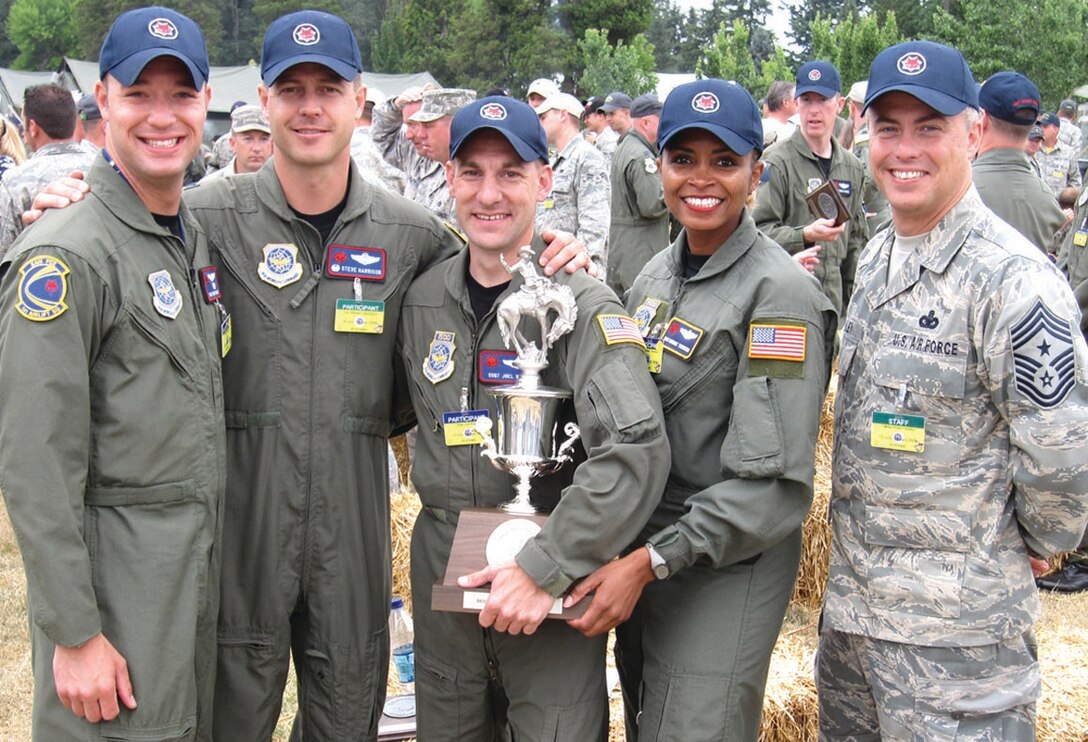 From left to right: Tech. Sgt. Bret Baker, 1st Airlift Squadron special air missions flight attendant, Col. Steve Harrison, 89th Airlift Wing commander, Staff Sgt. Joel Rose, 1st Airlift Squadron special air missions flight attendant, Master Sgt. Monique "Mo" Townsend, 89th Operations Group special air missions flight attendant, and Chief Master Sgt. Robert Sealey, 89 AW command chief master sergeant, pose with the 1st place trophy for the Flight Attendant Egress Competition at the 2009 Air Mobility Command Rodeo at McCord AFB, Wash., July 24. Four teams competed in the competition which consisted of an aircraft evacuation following a simulated 'planned emergency landing.' They were scored based on preflight of emergency equipment, giving appropriate briefings and following aircraft procedures. (U.S. Air Force photo/ Airman 1st Class Patrick McKenna)