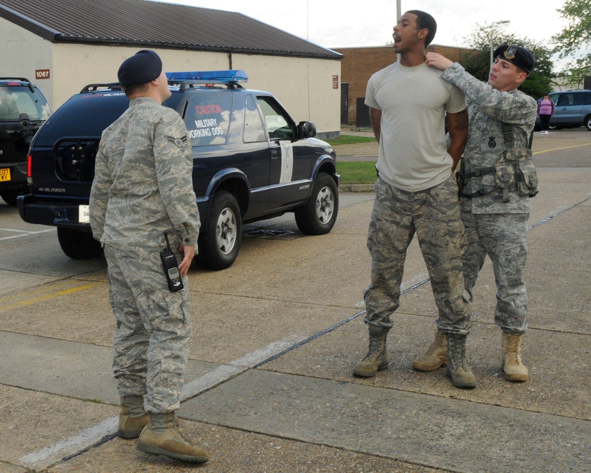 Airman 1st Class Brian Fitch, 48th Security Forces Squadron, inspects the mouth of a mock perpetrator, played by Airman 1st Class Melvin Walker, 48th SFS, while he is restrained by Airman 1st Class Chris Napier, 48th SFS, during a quality control exercise July 30, 2009 at RAF Lakenheath. (U.S. Air Force photo/Airman 1st Class Eboni Knox)