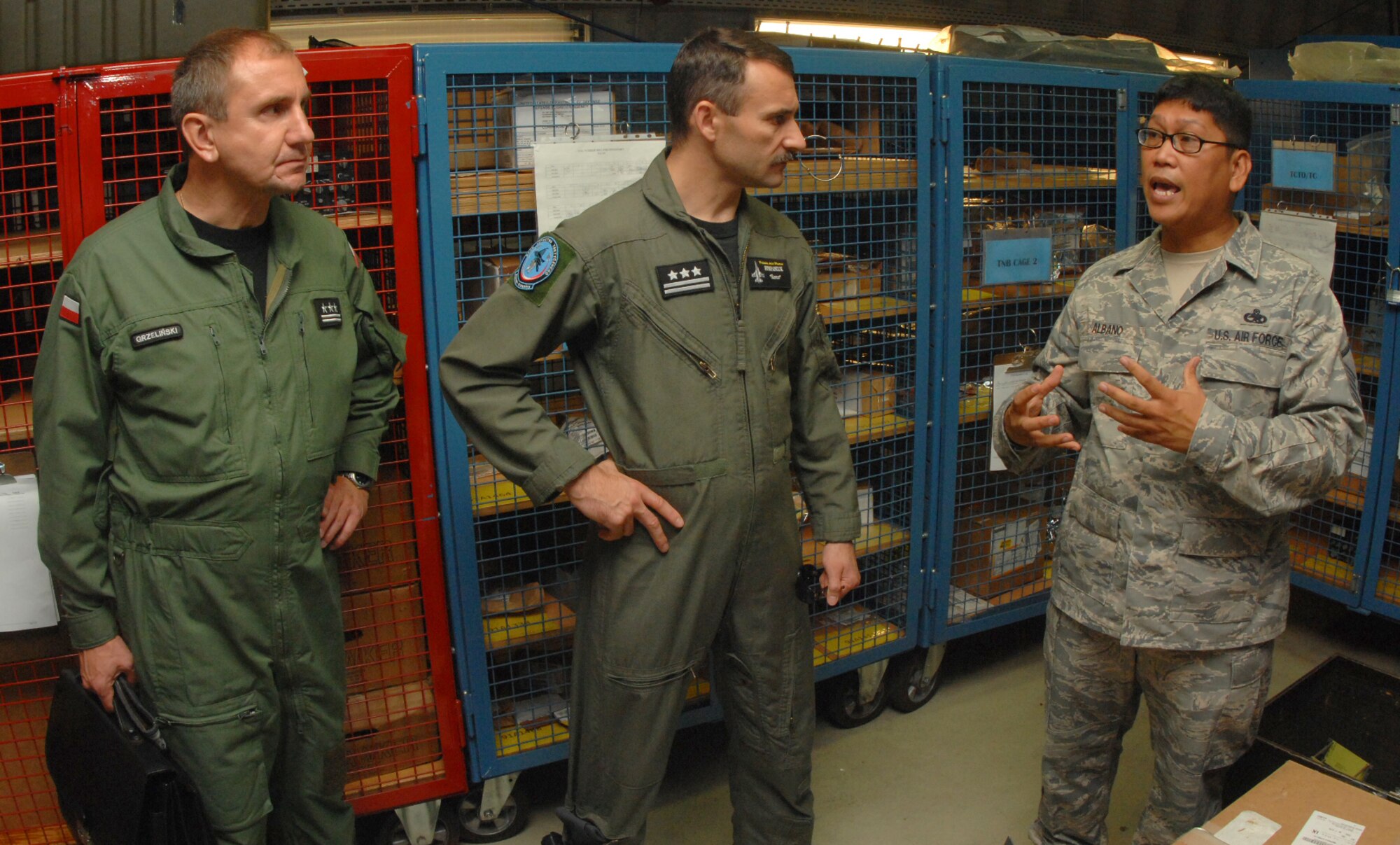 SPANGDAHLEM AIR BASE, Germany - Master Sgt. Stephen Albano, 52nd Aircraft Maintenance Squadron aircraft section chief, explains the aircraft parts supply system storage area processes to Col. Ryszard Grzelinski (left), deputy chief of the Polish air force, and Col. Rocislaw Stepaniuk, 31st Air Base commander, from Krzesiny Air Base, Poland, during their visit to Spangdahlem Air Base July 29. Spangdahlem was designated the "sister-wing" of the Polish air force in 2006 to assist with improving the operations of their new F-16 Fighting Falcon fleet. (U.S. Air Force photo by Airman 1st Class Nick Wilson)