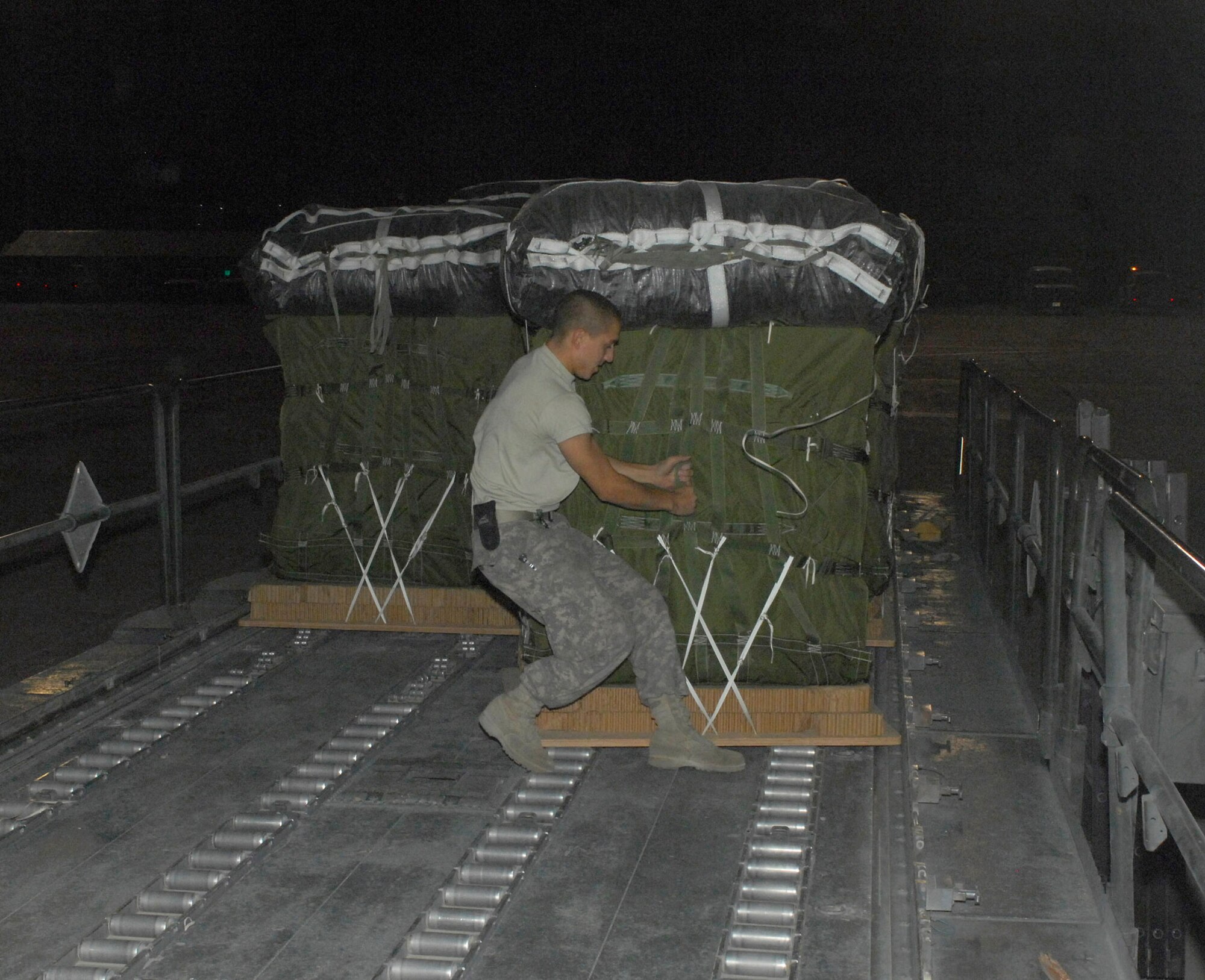 BAGRAM AIRFIELD, Afghanistan - Army Specialist Joshua Vazquez, 612th Port Master Detachment, pulls on the straps of a pallet destined for an airdrop mission. Specialist Vazquez is deployed from Fort Bragg, N.C., and hails from El Centro, Calif. (U.S. Air Force photo/Tech. Sgt. John Jung)