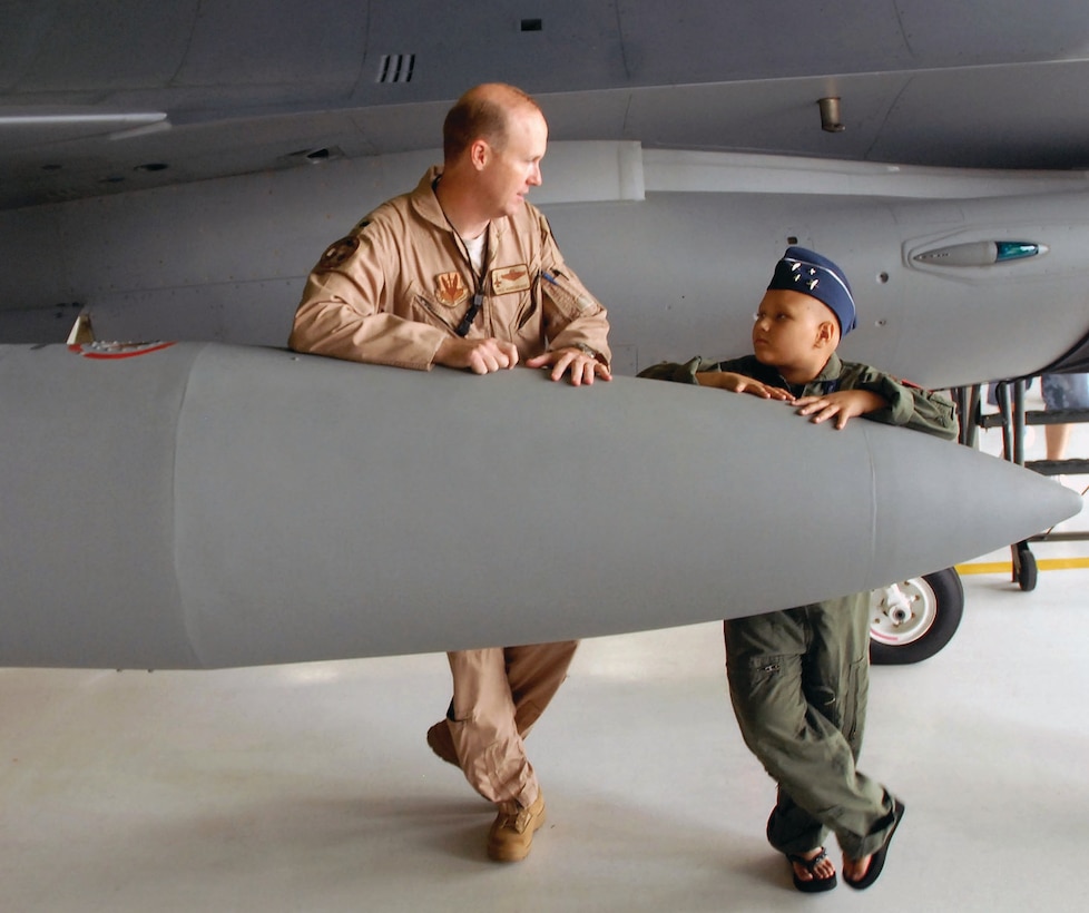 Lieutenant Col. Chris Hardgrave, left, 121st Fighter Squadron F-16 Fighting Falcon pilot, talks with Kayla Kiley, who was visiting the squadron as part of the Pilot for a Day program, at Andrews Air Force Base, Md., July 23. The Pilot for a Day program, which started at Andrews in 2004, allows children with serious or life-threatening illnesses, and their families, to meet and interact with personnel from a variety of units and get hands-on demonstrations of the aircraft and equipment. (Photo by Sgt. 1st Class Jon Soucy)