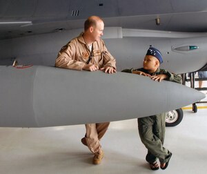 Lieutenant Col. Chris Hardgrave, left, 121st Fighter Squadron F-16 Fighting Falcon pilot, talks with Kayla Kiley, who was visiting the squadron as part of the Pilot for a Day program, at Andrews Air Force Base, Md., July 23. The Pilot for a Day program, which started at Andrews in 2004, allows children with serious or life-threatening illnesses, and their families, to meet and interact with personnel from a variety of units and get hands-on demonstrations of the aircraft and equipment. (Photo by Sgt. 1st Class Jon Soucy)