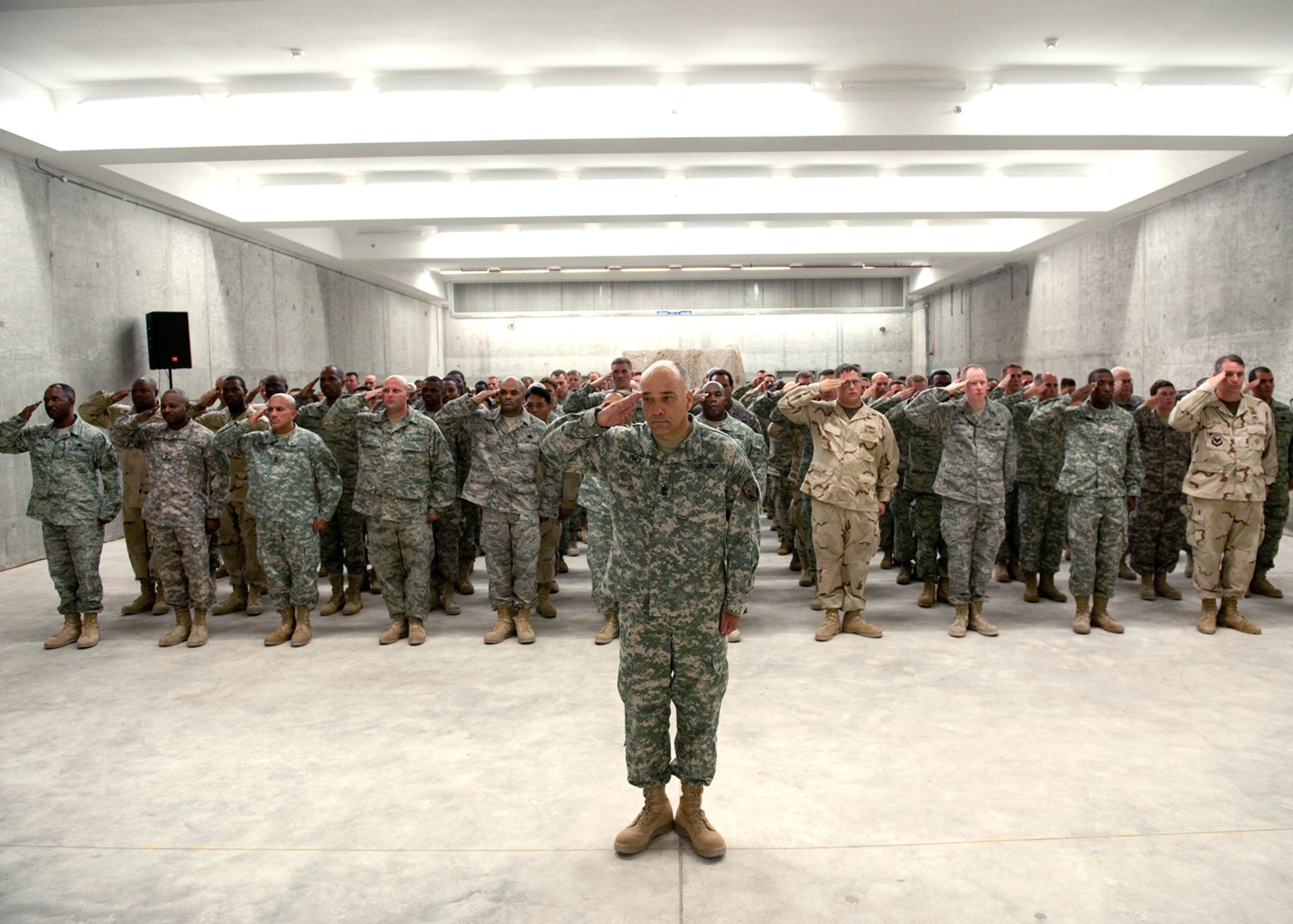 Military members of Special Operations Command Central render honors during the playing of the national anthem at a ribbon-cutting ceremony for the new SOCCENT main headquarters July 29 in Southwest Asia. SOCCENT officials plan, prepare and direct special operations missions in support of operations Iraqi Freedom and Enduring Freedom. (U.S. Air Force photo/Staff Sgt. Robert Barney)