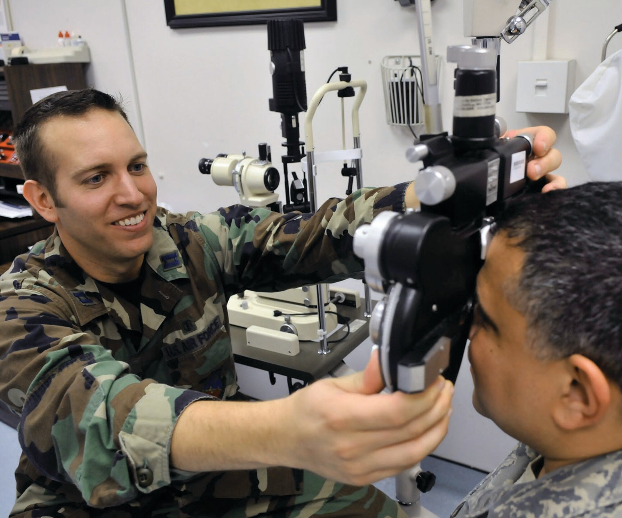 Captain Peter Carra, 779th Medical Operations Squadron optometrist, uses a phoropter to measure a patient’s visual acuity during an eye examination at the optometry clinic  July 22 at Malcolm Grow Medical Center. After looking through a series of lenses, the optometrist is able to determine what prescription best fits that patient's eyes. (U.S. Air Force photo by Senior Airman Renae Kleckner)