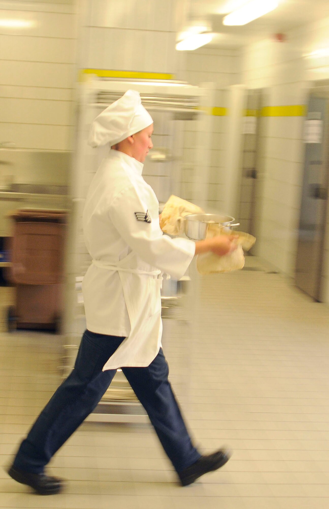 U.S. Air Force Senior Airmen Sheryl Stewart, 86th Services Squadron, food service journeyman moves briskly to her preparation station during the U.S. Air Forces in Europe Top Chef Competition at the Lindberg Hof Dining Facility on Kapaun Air Station July 30, 2009. (U.S. Air Force photo by Tech. Sgt. Kenneth Bellard)
