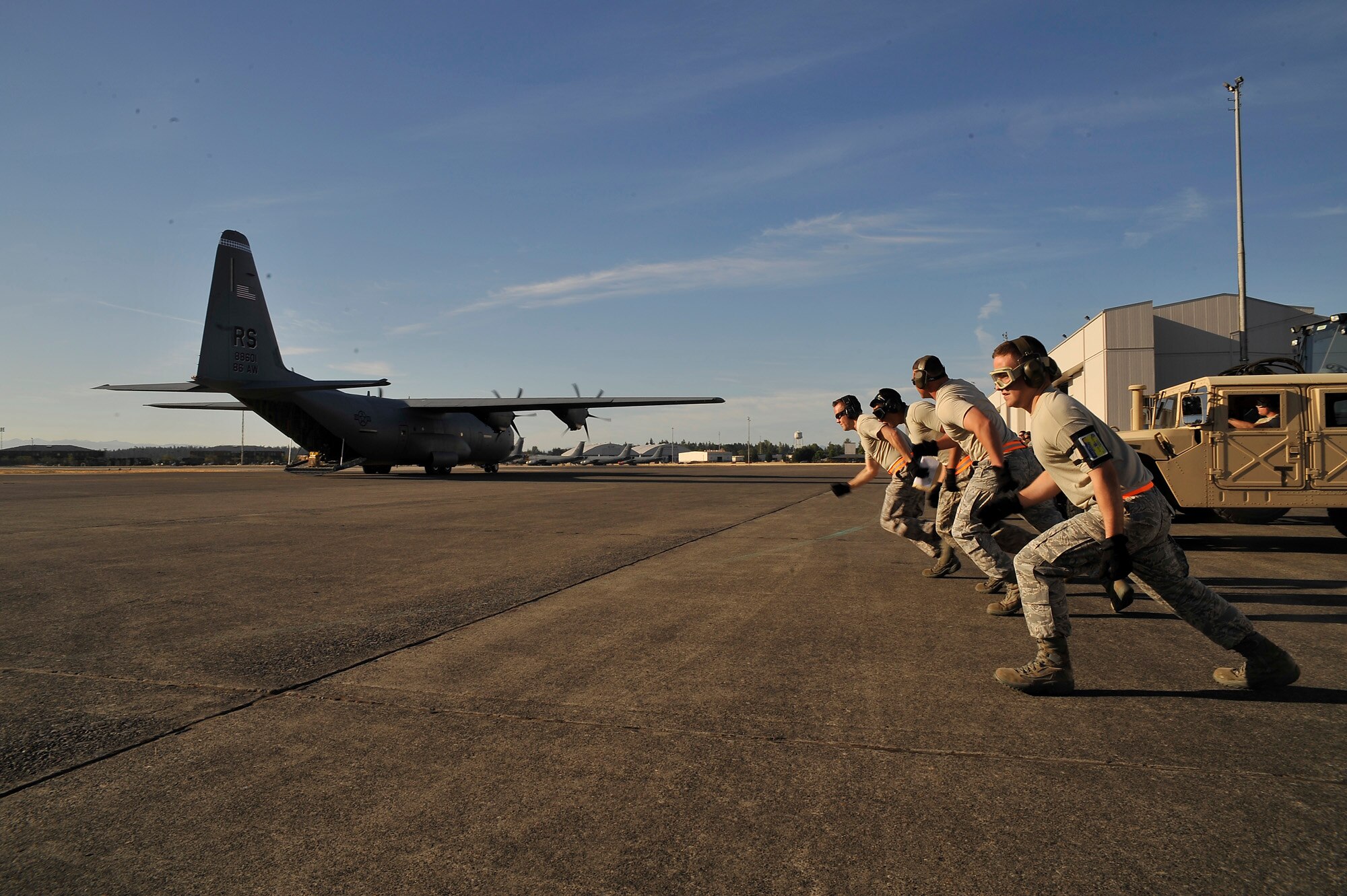 The Aerial Port team from the 435th Contingency Response Group races off to rapidly load a HMMVV, trailer and pallet in the back of C-130 with its engines running during the Air Mobility Command Rodeo 2009 competition at McChord Air Force Base, Wash. More than 50 Airmen from Team Ramstein were part of the 2,500 servicemembers from around the Air Force and the globe participating in the rodeo. The competition, which went from Jul 19 to 24, is a bi-annual mobility readiness exercises that brings teams together to compete in more than 50 judged events spanning the categories of aerial port, aeromedical evacuation, aircrew, fit to fight, maintenance and security forces.  (Courtesy photo).