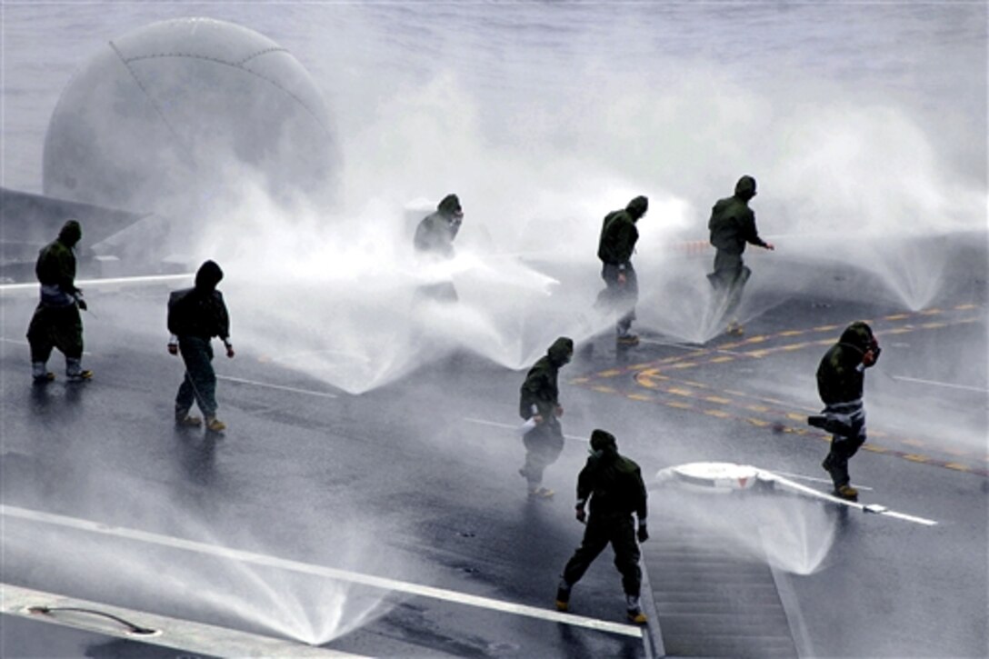 U.S. Navy damage controlmen and flight deck personnel inspect the spray nozzles on the flight deck aboard the nuclear-powered aircraft carrier USS Nimitz during a salt water counter-measure wash-down test in Pacific Ocean, July 23, 2009. Nimitz is currently underway in preparation for a regularly scheduled deployment.
