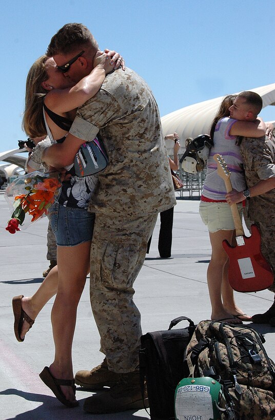 Lance Cpl. Adam Horn, Marine Attack Squadron 214 airframe mechanic, embraces his wife Lindsey after returning home to the Marine Corps Air Station in Yuma, Ariz., from a seven-month deployment with the 13th Marine Expeditionary Unit aboard the USS Boxer July 31, 2009. Approximately 100 VMA-214 and Marine Aviation Logistics Squadron 13 Marines and sailors returned to Yuma. While deployed, the Marines aided in counter-piracy operations off the coast of Africa, near the Gulf of Aden, including the recovery of Richard Phillips, a civilian cargo ship captain who was taken hostage by Somali pirates.