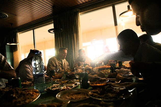 Col. Vincent A. Coglianese, the chief of staff of the 2nd MLG (Fwd), and Maj. Christian M. Rankin, the commanding officer of Camp Al Taqaddum's security detachment from 1st Battalion, 8th Marine Regiment, discuss business while enjoying traditional Iraqi cuisine at the Habbaniyah Tourist Village in Iraq, June 1, 2009. During meetings throughout the day, Rankin assured the resort's staff of his commitment helping the hotel and resort to continue to flourish. (Photo-illustration by Cpl. Bobbie A. Curtis)