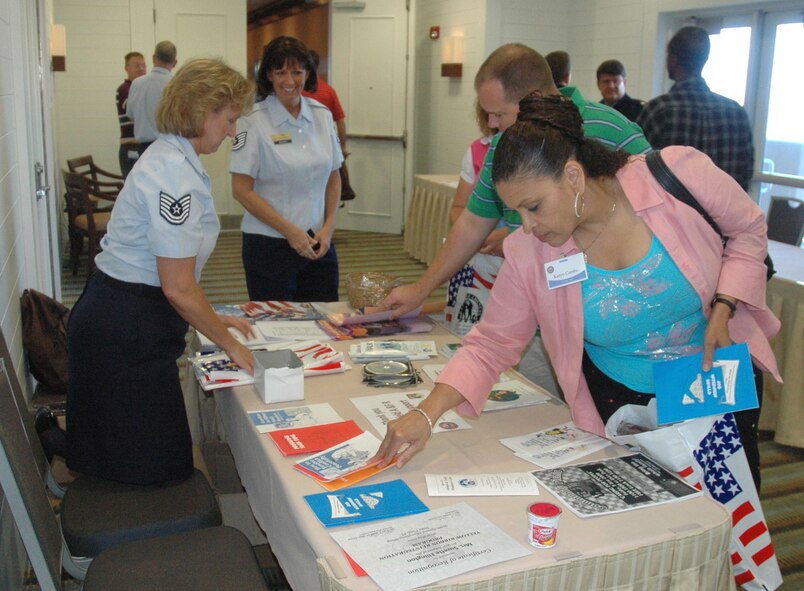 Air Force Reserve Master Sgt. Karyn Combs, 919th Special Operations Wing Equal Opportunity superintendent, (foreground) a recent war returnee, picks up brochures at one of many informational tables available inside the Pensacola Beach Hilton Hotel Saturday.  Duke Field’s first-ever Yellow Ribbon Reintegration Program event offered the reservists and their families dozens of special briefings and opportunities to relax and learn about the wide variety of available benefits and other programs aimed at easing their transition home.  U.S. Air Force photo/James Brock III