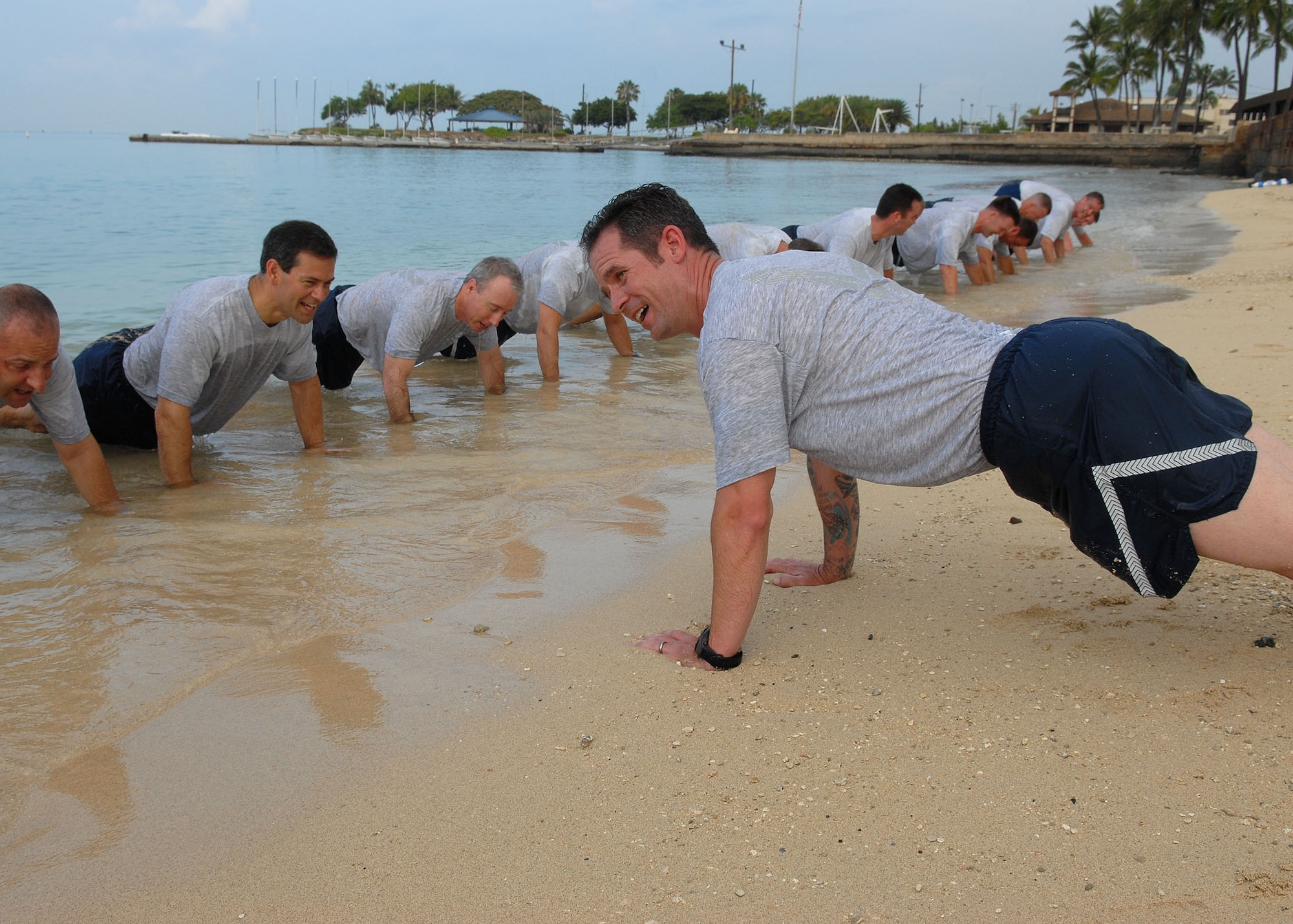 Senior Master Sgt. JJ Little, Pacific Air Forces’ Inspector General team, leads a beach physical training session at Hickam Air Force Base, Hawaii, May 27. Approximately 70 people participated in the physical training session, which included a 1.5-mile run to Hickam Beach, a half-hour session of calisthenics and team building, followed by a 1.5-mile run back to the starting point. The directorates participating in the beach session were A3, A4, A5 and A8. (U.S. Air Force photo/Tech. Sgt. Jerome Tayborn)