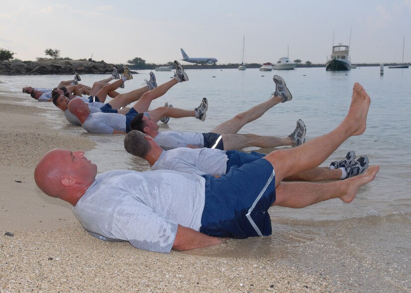 Members of Pacific Air Forces’ A-staff perform scissor kicks at Hickam Air Force Base, Hawaii, May 27, 2009, during a morning “beach PT session.” In addition to new PT test standards implemented January 2010, Air Force officials are restructuring the requirement for commanders to conduct regular, group physical training. The intent of this policy revision is to give commanders more ability to design and develop their unit PT programs to meet the mission of their units and AFSCs. (U.S. Air Force photo/Tech. Sgt. Jerome Tayborn) 