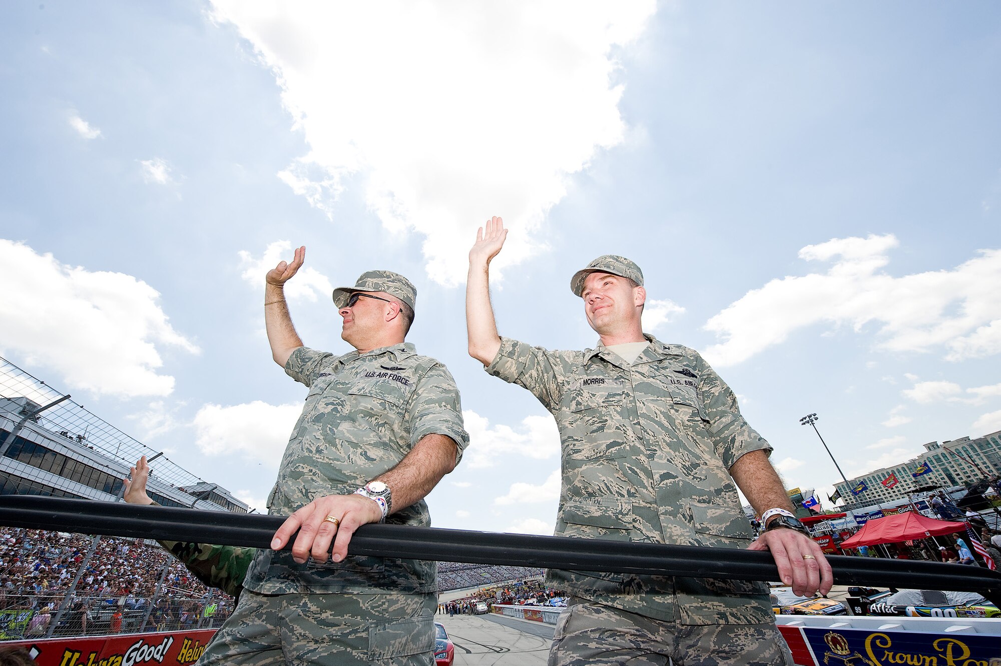 Cols. Randal L. Bright (left) and Manson O. Morris, the two wing commanders from Dover Air Force Base, Del., wave to NASCAR spectators during a pre-race parade lap at the Dover International Speedway May 31. Colonel Bright commands the Reserve associate unit and Colonel Morris leads the regular Air Force unit, both of which support the C-5 and C-17 airlift mission. (U.S. Air Force photo/Roland Balik)