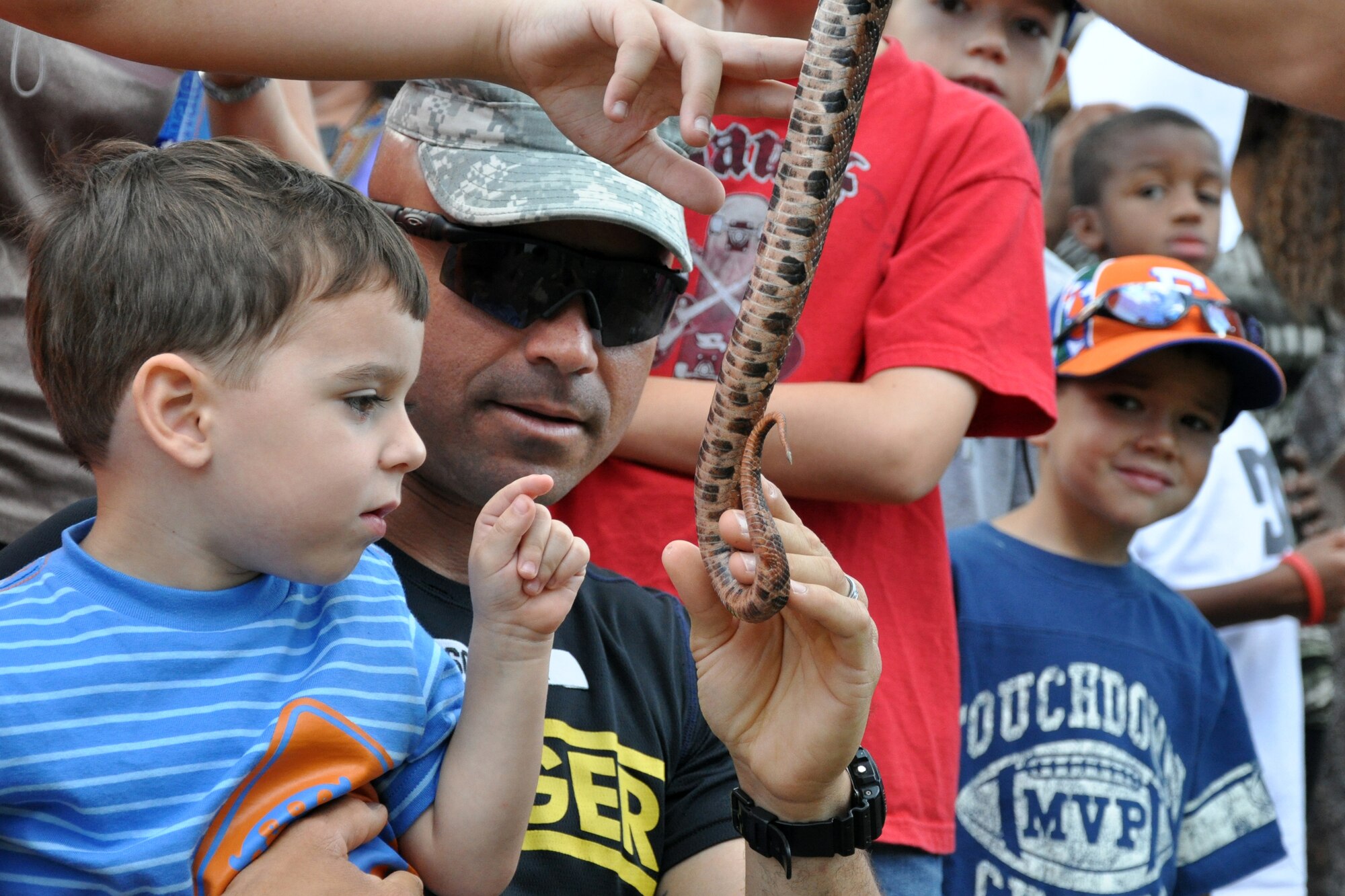 EGLIN AIR FORCE BASE, Fla. – A soldier and his son get a hands-on experience with live snakes and other reptiles during a reptile demonstration when the Army’s 6th Ranger Training Battalion hosted an open house May 30. The event was a chance for the public to witness how they train and operate in extreme situations. The event included a variety of displays such as dive equipment, weapons, and zodiac boats. Demonstrations featured at the event included hand-to-hand combat demonstration, parachute jump, and an urban operations demonstration. (U.S. Air Force photo/ Airman Anthony Jennings)