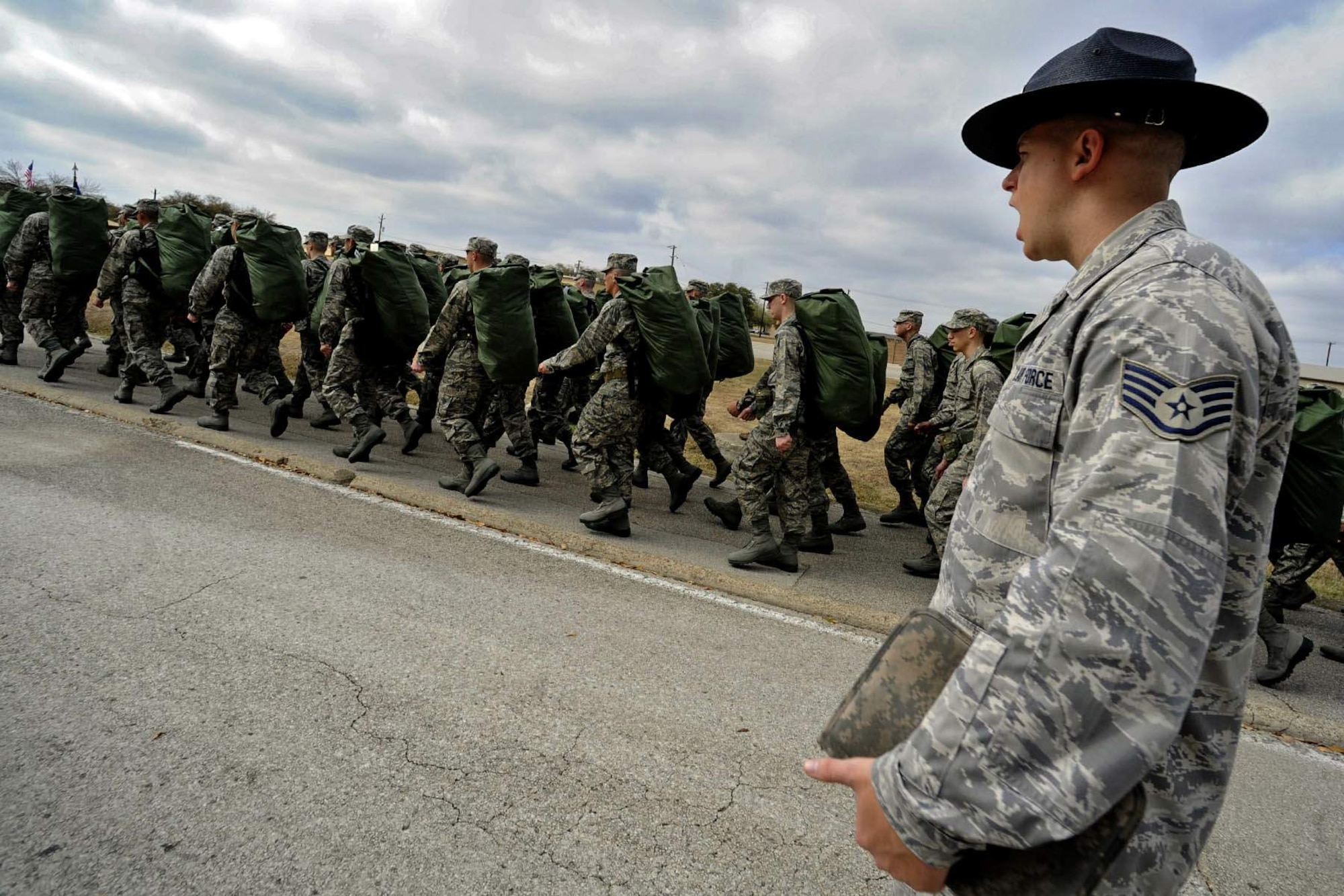 Staff Sgt. Robert George, a military training instructor at Lackland Air Force Base, Texas, marches his unit following the issuance of uniforms and gear.  Recruits are molded into warrior Airmen through a recently expanded Air Force Basic Military Training program. (U.S. Air Force photo/Master Sgt. Cecilio Ricardo)