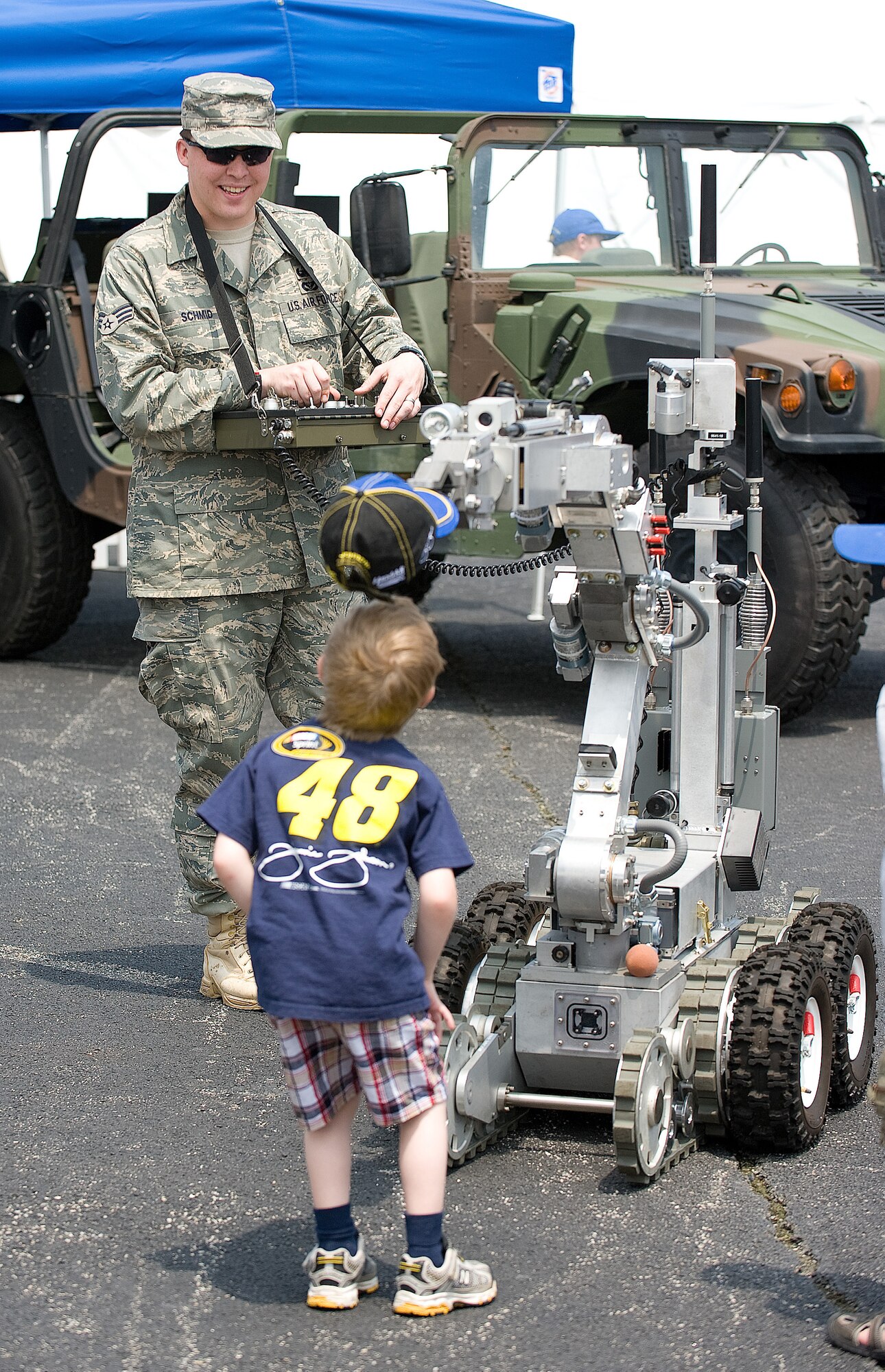 A young Jimmie Johnson fan watches while Senior Airman Robert Schmid, 436th Airlift Wing, demonstrates the capability of a robot used by the explosive ordnance team at Dover Air Force Base, Del. Throughout the May 30-31 NASCAR event, reservists and regular Air Force members from the 512th and 436th AWs participated in various events showcasing some of Team Dover's capabilities at an arena which seats 135,000. (Air Force photo/Jason Minto)
