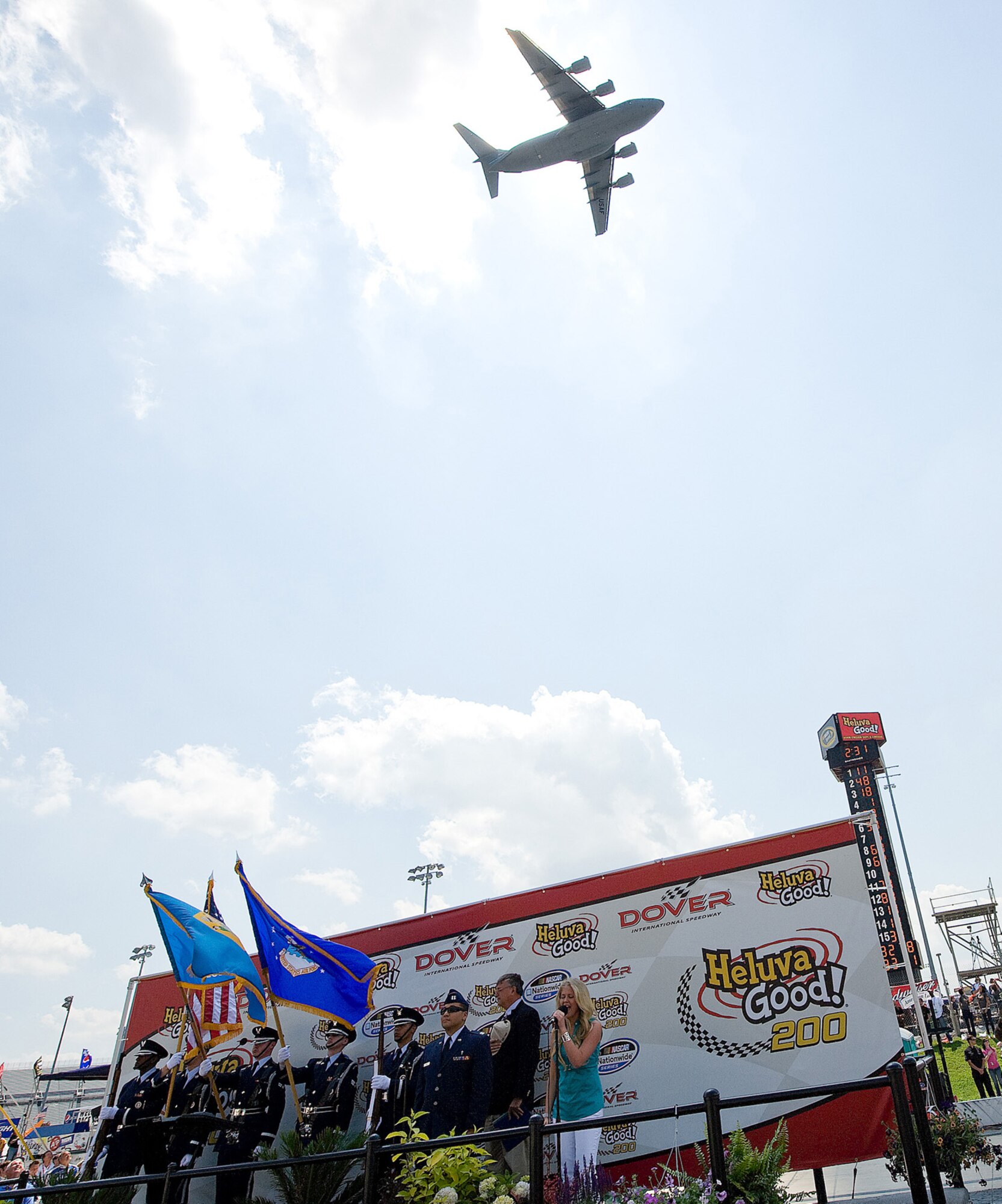 A C-17 Globemaster III aircrew, assigned to Dover Air Force Base, Del., performed a flyover as part of a pre-race ceremony at the Dover International Speedway May 30. Also pictured are members of the base's honor guard, which posted the colors in a stadium that seats 135,000. Over the weekend, reservists and regualr Air Force members from the 512th and 436th Airlift Wings participated in various events showcasing Air Force and AF Reserve capabilities. (Air Force photo/Jason Minto)