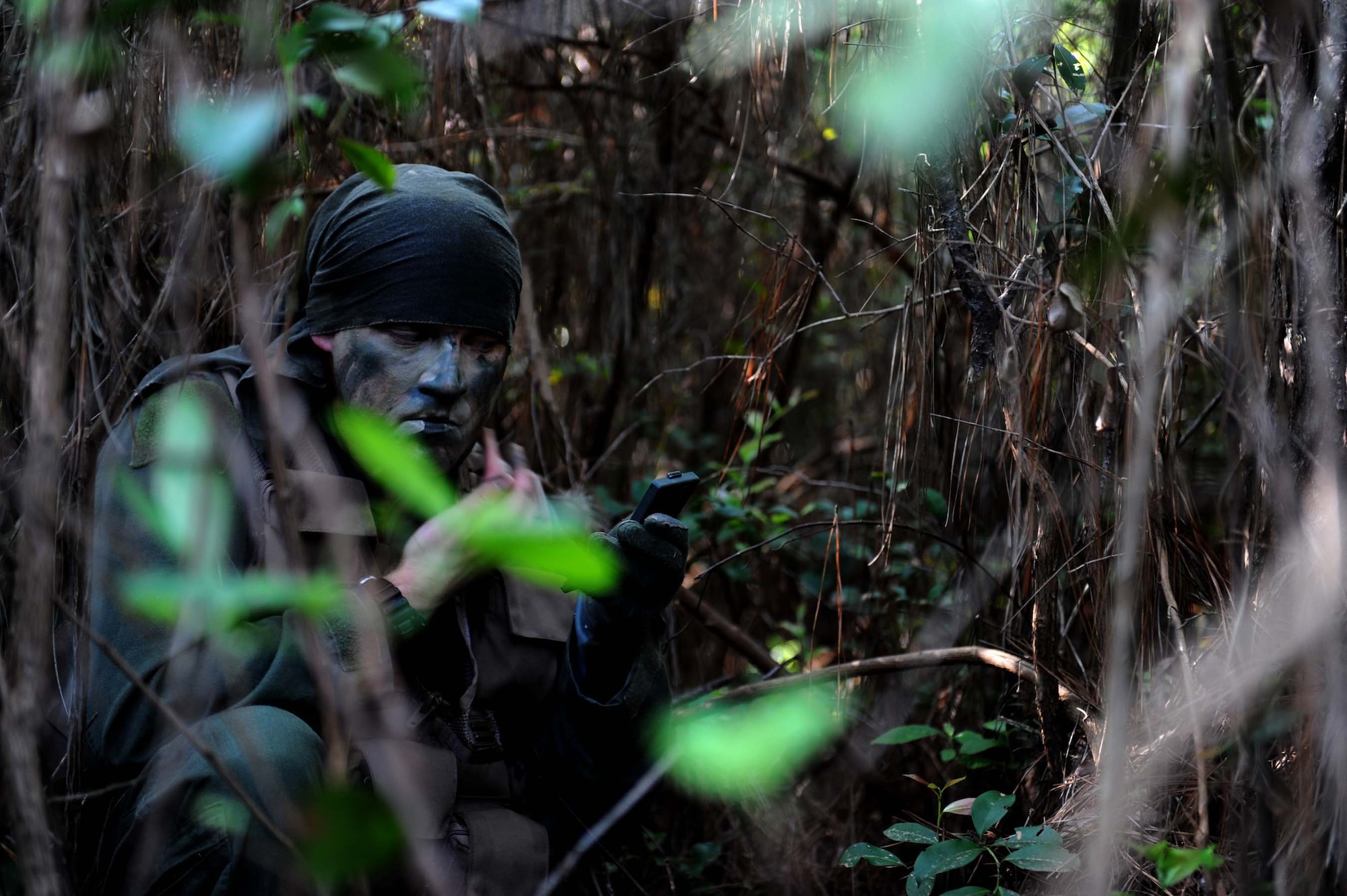 SHAW AIR FORCE BASE, S.C. - Senior Airman Justin Carson, 20th Fighter Wing Survival, Evasion, Resistance and Escape specialist,applies camouflage in a hole-up site during training on Poinsett Range May 28, 2009. SERE Specialists train aircrew and high-risk personnel on how to employ personnel recovery techniques, tactics and procedures in many diiferant scenarios. (U.S. Air Force photo/Senior Airman Matt Davis)