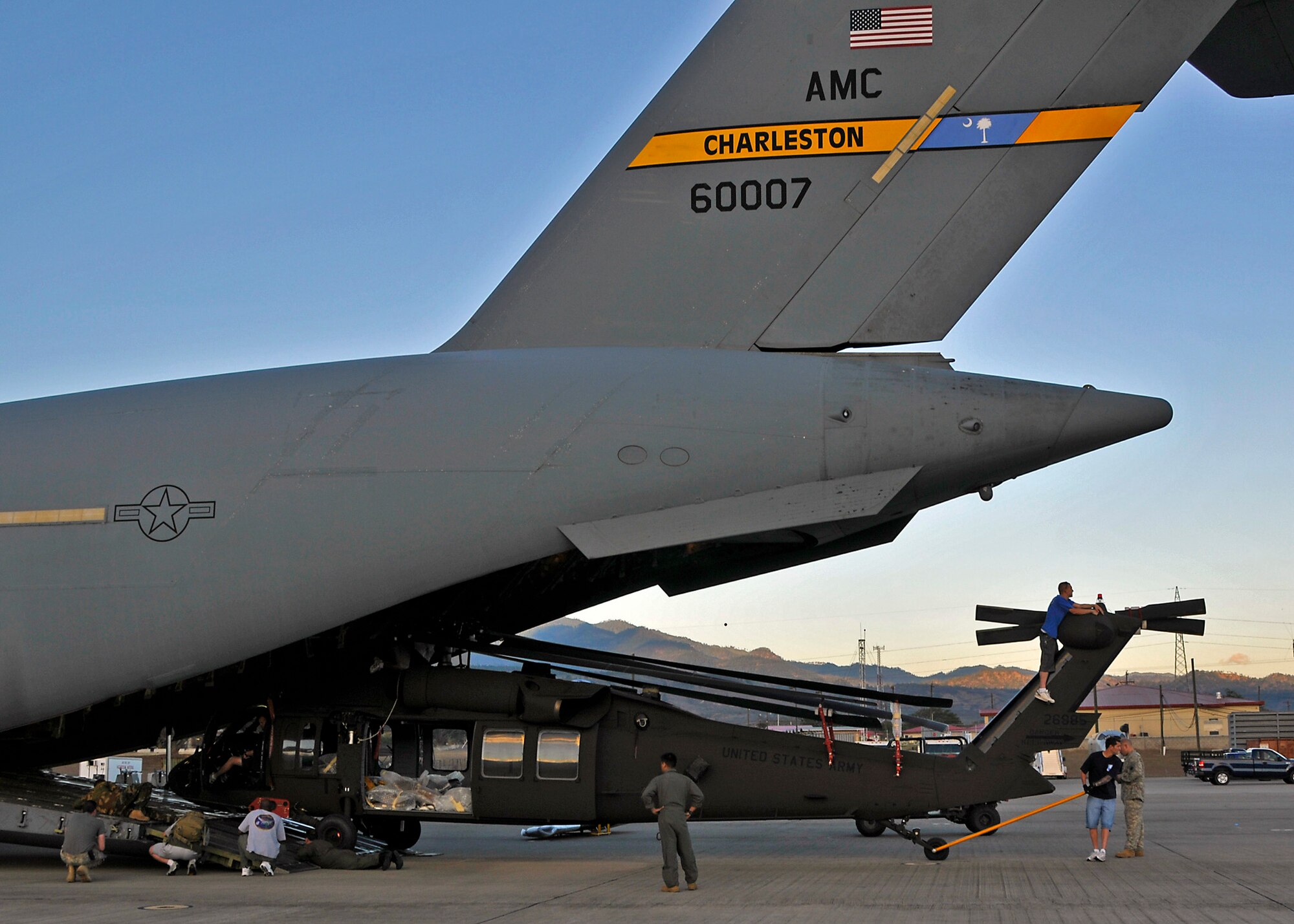 Members of the 701 Airlift Squadron, Charleston Air Force Base, S.C., load an Army Blackhawk helicopter to a C-17 Globemaster III while in Soto Cano Air Base, Honduras.  The Blackhawk helicopters will be transferred back to the U.S. for regular scheduled maintenance. (Air Force photo / Major Chett Collier) 