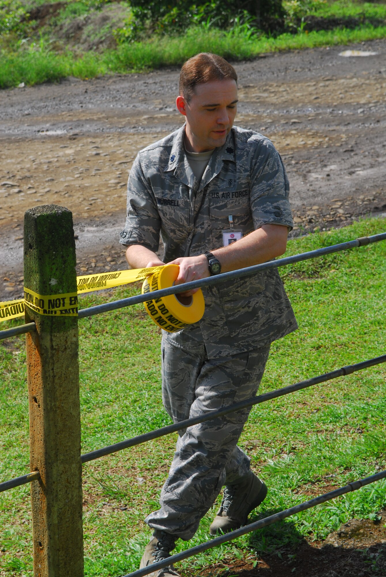NORTHERN PROVINCE OF ALAJUELA, Costa Rica –  Putting up Spanish and English "Do Not Enter" tape, Lt. Col. Erich Murrell, the 30th Medical Support Squadron commander, cordons off an area of a local school here May 19. Medical personnel from the 30th Space Wing deployed to Costa Rica May 16 - 30 as part of a humanitarian effort with local Costa Rican physicians. Medical specialists from both countries provided medical care to residents who are rarely seen by physicians due to living in isolated areas.(U.S. Air Force photo/Airman 1st Class Steve Bauer) 