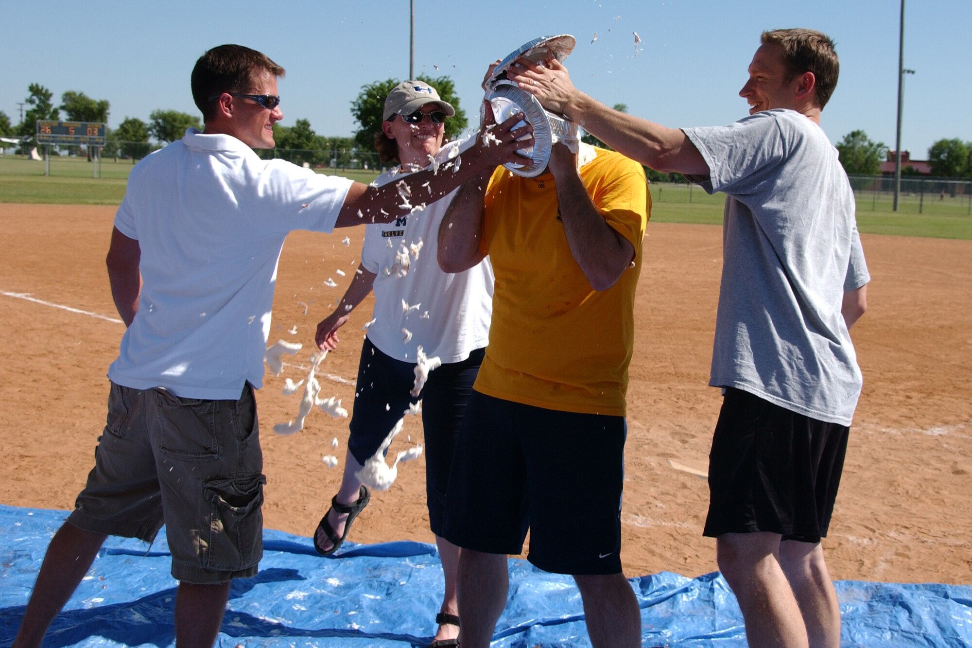 From left, Capt. James Demchak, 71st Flying Training Wing executive officer, Maj. Danielle Willis, Commander's Action Group chief and Maj. Matthew Crowell, 71st Flying Training Wing executive officer, hit Col. Richard Murphy with pies for charity. The Focus 5/6 raffled chances to pie base leadership at the Senior Leadership Softball Classic May 29, with the proceeds going to the American Cancer Society. (U.S. Air Force photo by Staff Sgt. Brian Hill). 