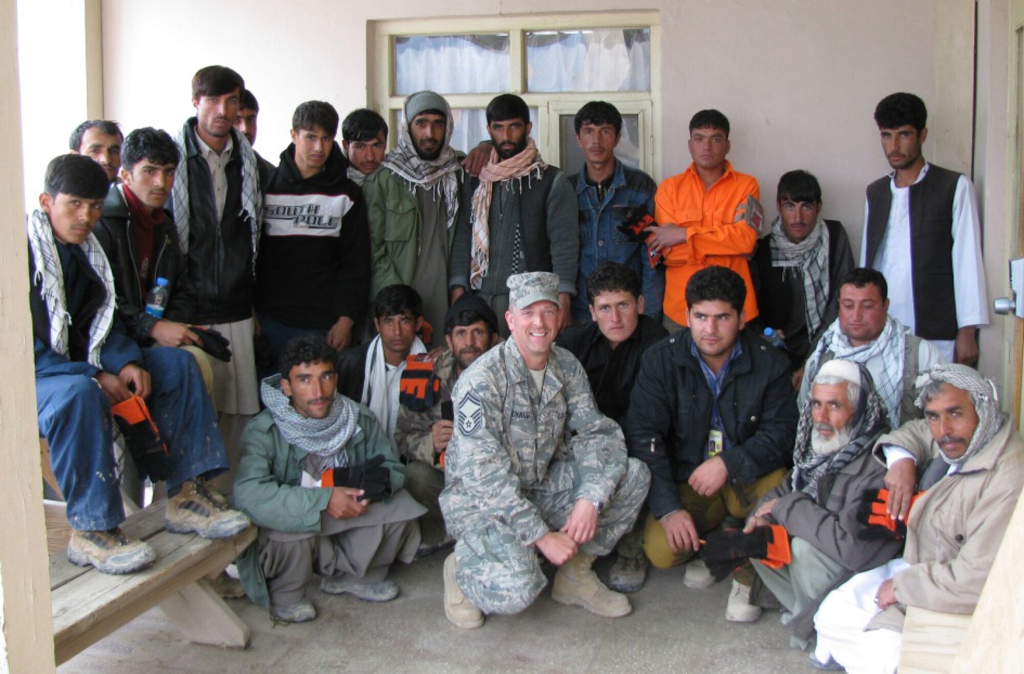 Senior Master Sgt. Rick Michaud, deployed from the 439th Civil Engineering Squadron, takes a break from his work to pose for a photo with local Afghans. (Courtesy photo)      