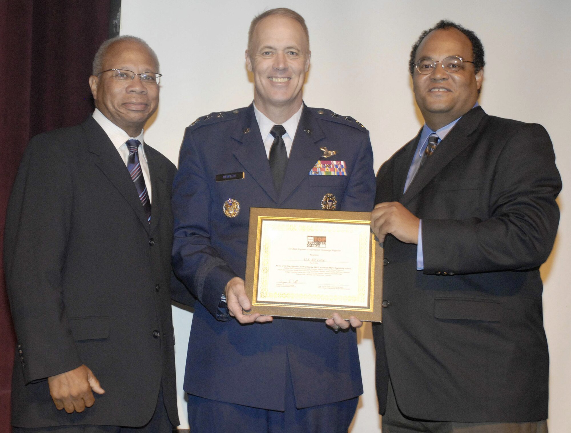 Lt. Gen. Richard Y. Newton III, deputy chief of staff for manpower and personnel, accepts an award on behalf of the Air Force May 29 at Howard University here, from Dean Jim Johnson of Howard University's College of Engineering, Architecture, and Computer Science, and Dr. Tyrone Taborn, CEO of Career Communications Group. The Air Force was recently named among the "Top Supporters of Historically Black Colleges and Universities" by the U.S. Black Engineer and Information Technology magazine. (U.S. Air Force photo/Master Sgt. Stan Parker)